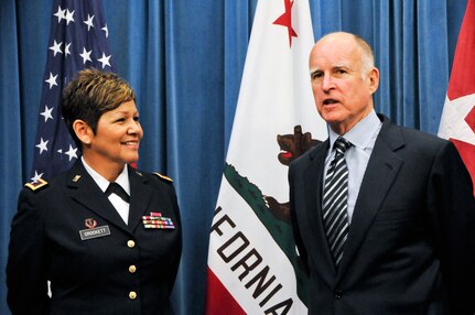 Army Col. Sylvia Crockett listens as Gov. Edmund Brown Jr. gives comments prior to her promotion to the rank of brigadier general on March 28, 2012 at the state Capitol in Sacramento, Calif. Crockett is the first Hispanic woman to achieve the rank of general officer in the history of the California National Guard.