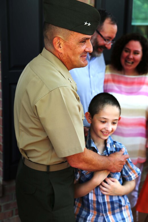 Maj. Gen. Frederick Padilla, director of operations for Plans, Policies and Operations, Headquarters Marine Corps, celebrates with Andrew Starr after a ceremony awarding Starr the title “honorary Marine.” Seven-year-old Andrew, having been diagnosed with Neurofibromatosis Type 1, is only the second person to receive the title in 2014. 