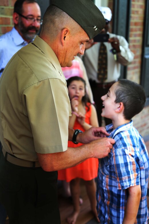 Maj. Gen. Frederick Padilla, director of operations for Plans, Policies and Operations, Headquarters Marine Corps, pins an eagle, globe and anchor pin on Andrew Starr’s lapel during a ceremony awarding Starr the title “honorary Marine.” Seven-year-old Andrew is one of less than 100 people to ever receive the title since its conception in 1992.