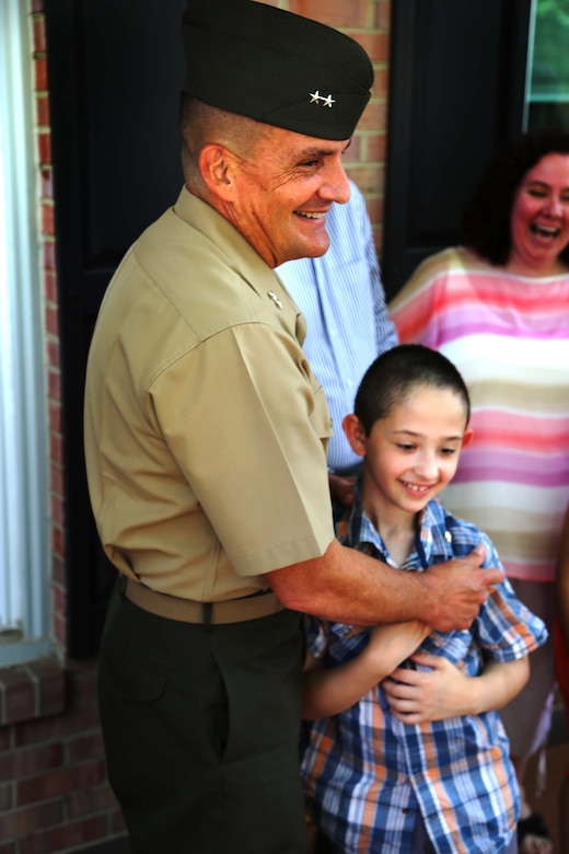 Maj. Gen. Frederick Padilla, director of operations for Plans, Policies and Operations, Headquarters Marine Corps, celebrates with Andrew Starr after a ceremony awarding Starr the title “honorary Marine.” Seven-year-old Andrew, having been diagnosed with Neurofibromatosis Type 1, is only the second person to receive the title in 2014. 