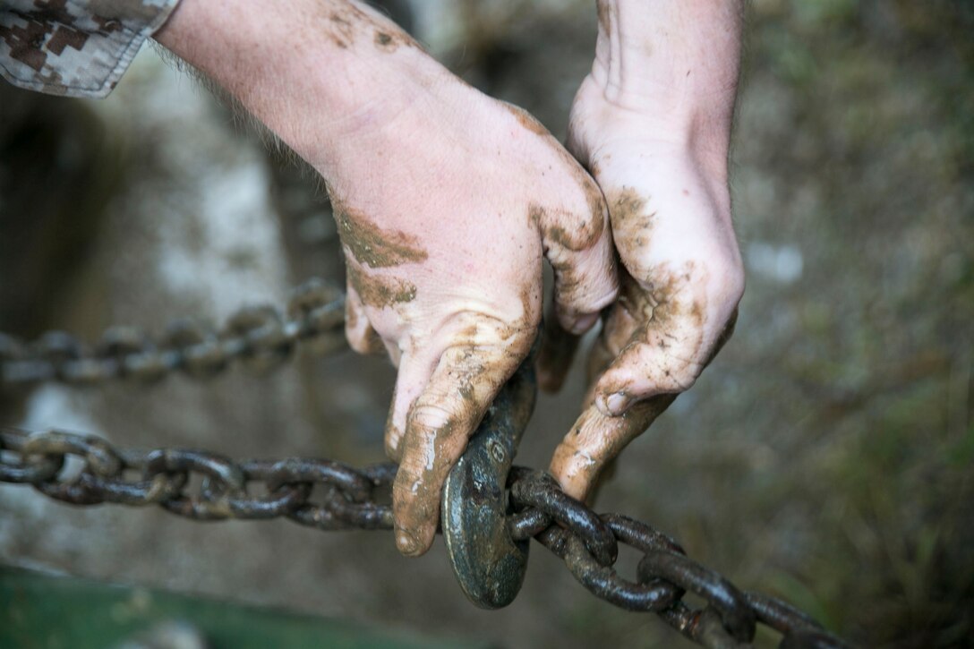 A Marine secures a hook onto a chain June 24 during Exercise Coral Thunder at Kadena Air Base. This training refreshed Marines on some of the basic skills required to deploy. The Marine is with Marine Air Support Squadron 2, Marine Air Control Group 18, 1st Marine Aircraft Wing, III Marine Expeditionary Force.