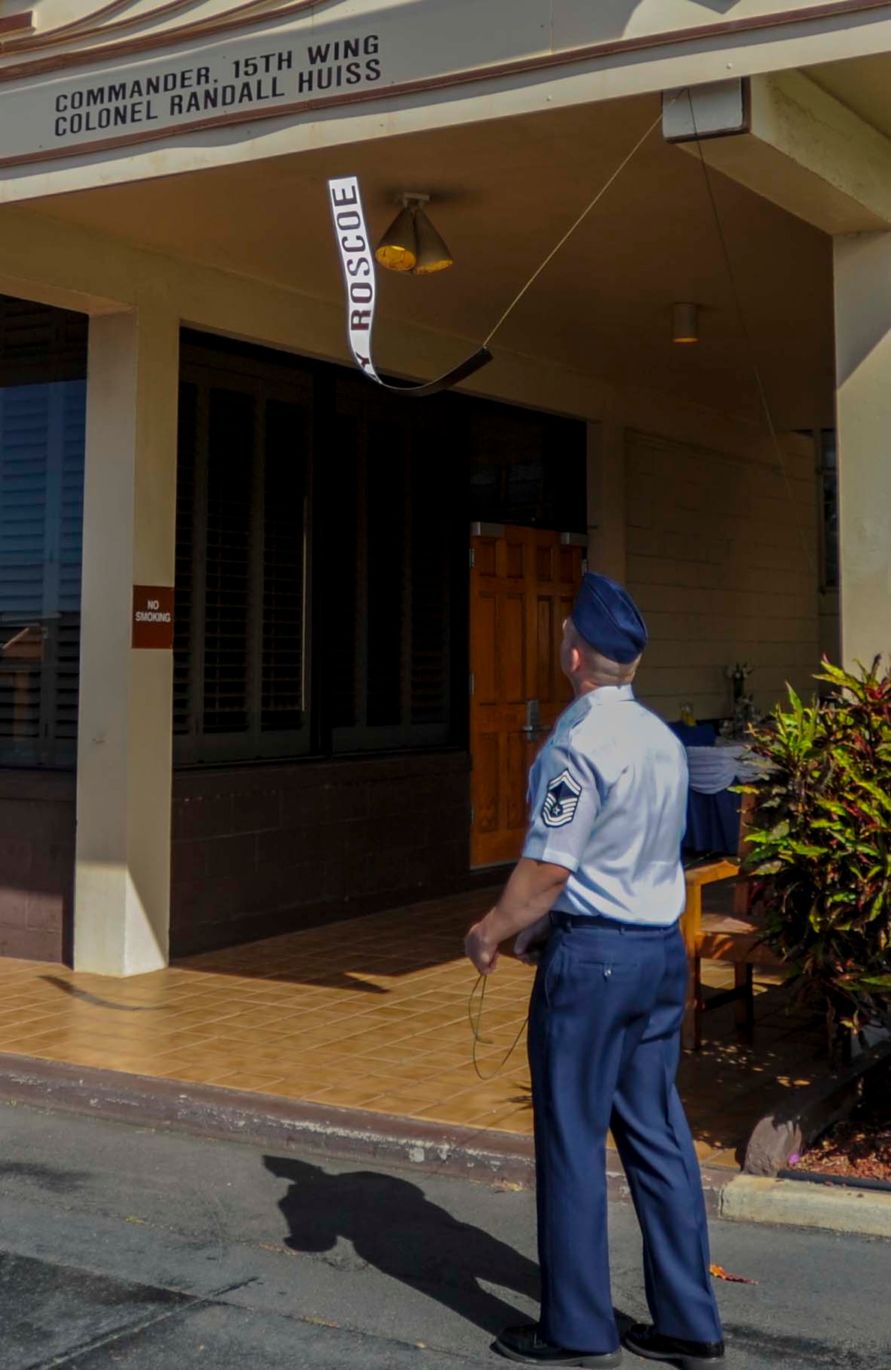 Senior Master Sgt. Jason Wondoloski, 647th Civil Engineer Squadron, unveils the new placard for Col. Randall Huiss, 15th Wing commander, on the base operations building on the flightline on Joint Base Pearl Harbor-Hickam, Hawaii, June 27, 2014. The placard signifies Huiss’ new responsibility as the senior Air Force Mission commander. (U.S. Air Force photo/Tech. Sgt. Terri Paden)