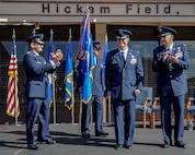 Lt. Gen. Russell Handy, Eleventh Air Force commander, left, and Col. Johnny Roscoe, former 15th Wing commander, right, clap just after Col. Randall Huiss, 15th Wing commander, officially took control of the wing during the change of command ceremony June 27, 2014, on the Joint Base Pearl Harbor-Hickam flightline. (U.S. Air Force photo/Tech. Sgt. Terri Paden)