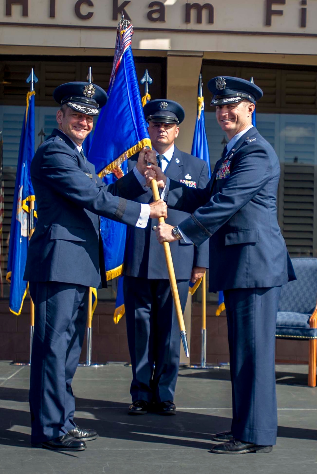 Lt. Gen. Russell Handy, Eleventh Air Force commander, passes the 15th Wing guidon to Col. Randall Huiss, the incoming 15th Wing commander, during the change of command ceremony June 27, 2014, on the Joint Base Pearl Harbor-Hickam flightline. During the ceremony, Huiss took command of the wing from Col. Johnny Roscoe. (U.S. Air Force photo/Tech. Sgt. Terri Paden)