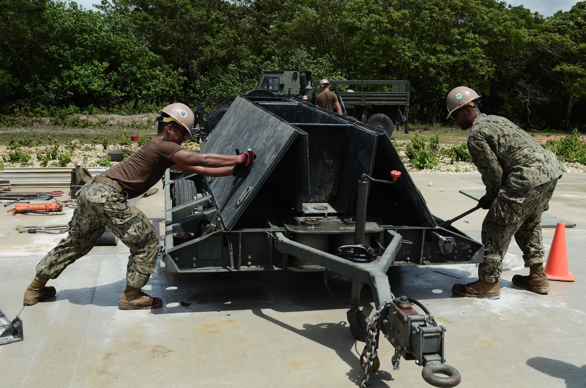 Seaman Janry Villaruz, exercise Silver Flag student, cranks a Mobile Aircraft Arresting System off the ground June 20, 2014, on Northwest Field, Guam. Members of a U.S. Navy construction battalion from Naval Base Guam participated in the mock Silver Flag course to give the Andersen instructors experience with conducting the training with actual students before the first official course is held in late 2014. (U.S. Air Force photo by Airman 1st Class Emily A. Bradley/Released)