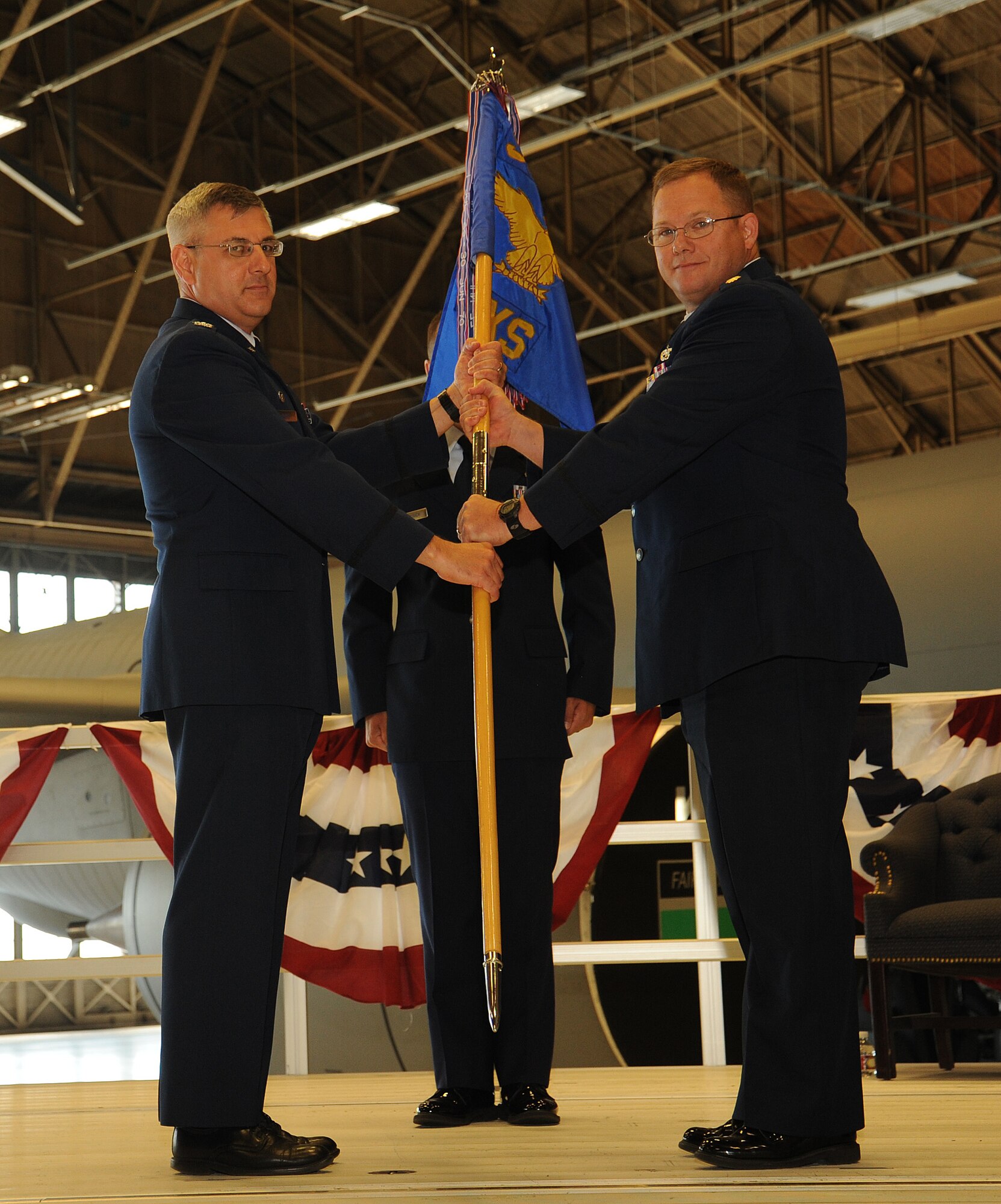 Maj. Leonard Shores takes the guidon from Col. Kenneth Timko during the 92nd Maintenance Squadron change of command at Fairchild Air Force Base, Washington, June 30, 2014. Timko is the 92nd Maintenance Group commander and Shores is now the 92nd MXS commander. A change of command is a military tradition that represents a formal transfer of responsibility for a unit from one commanding officer to another. (U.S. Air Force photo by Staff Sgt. Samantha Krolikowski/Released) 