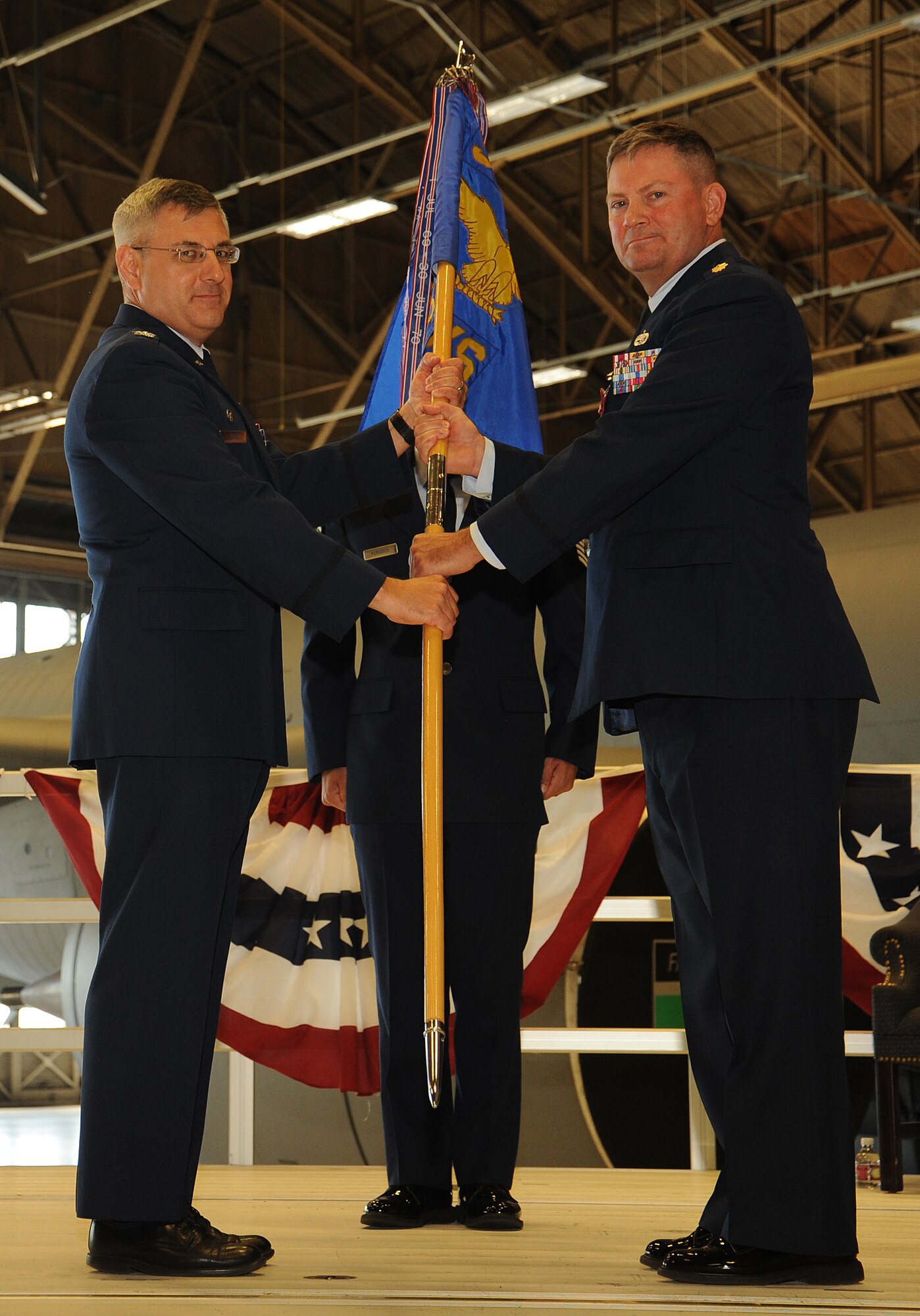 Maj. Sean Goode gives the guidon to Col. Kenneth Timko during a change of command ceremony at Fairchild Air Force Base, Washington, June 30, 2014. Timko is the 92nd Maintenance Group commander and Goode was the 92nd Maintenance Squadron commander. A change of command is a military tradition that represents a formal transfer of responsibility for a unit from one commanding officer to another. (U.S. Air Force photo by Staff Sgt. Samantha Krolikowski/Released) 