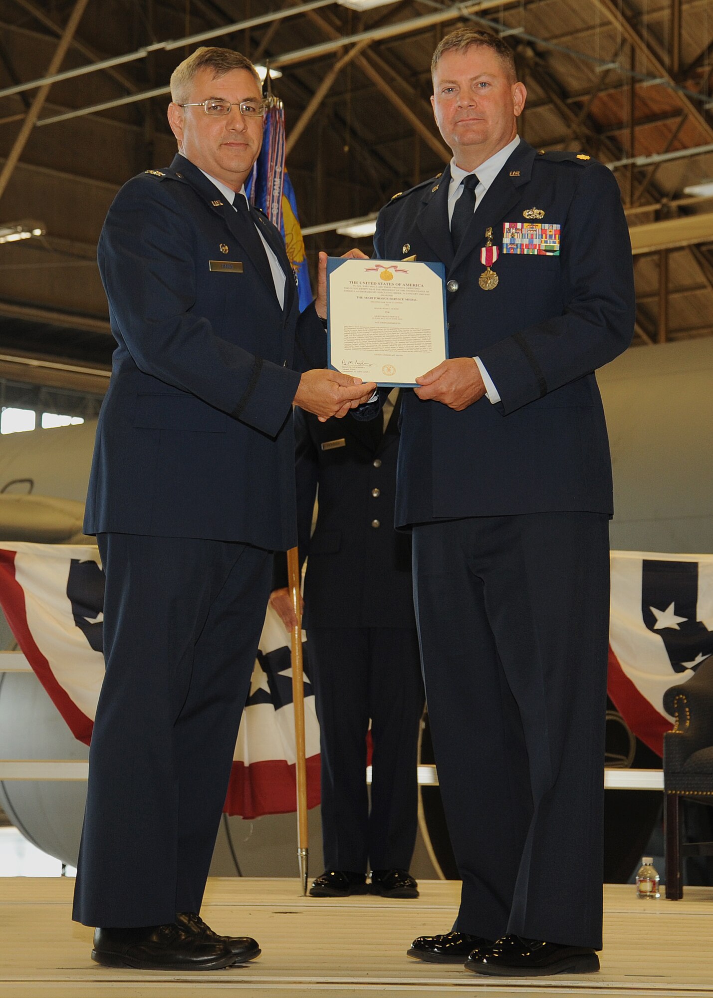 Col. Kenneth Timko presents the Meritorious Service Medal to Maj. Sean Goode at a change of command ceremony at Fairchild Air Force Base, Washington, June 30, 2014. Timko is the 92nd Maintenance Group commander and Goode was the 92nd Maintenance Squadron commander. A change of command is a military tradition that represents a formal transfer of responsibility for a unit from one commanding officer to another. (U.S. Air Force photo by Staff Sgt. Samantha Krolikowski/Released) 