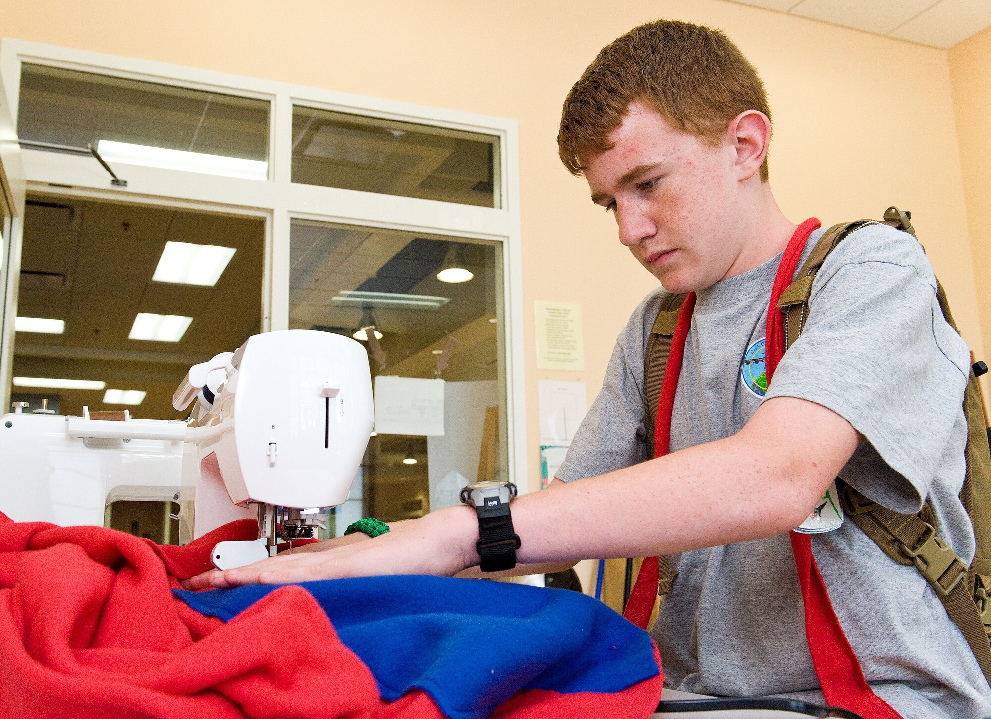 Colin Phillips, son of Lt. Col. Michael Phillips, 436th Mission Support Group deputy commander, sews a "quillow" June 27, 2014, at the Youth Center on Dover Air Force Base, Del. Phillips, who is enrolled in the Operation Military Kids camp, made his quillow for a Hero Pack and will be given to a child of a deployed or soon to be deployed parent. (U.S. Air Force photo/Roland Balik)