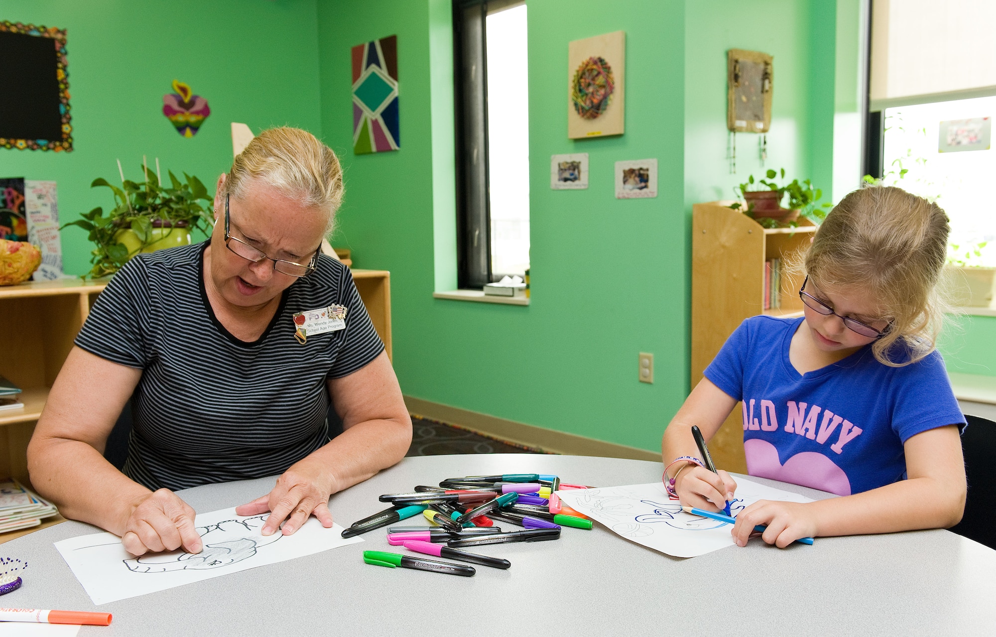 Jordan Marsh, right, daughter of Master Sgts. Angeline and Christopher Marsh, both assigned to the 436th Logistics Readiness Squadron, and Wendy Jones, left, 436th Force Support Squadron Youth Center school age program assistant, color a dolphin and elephant respectively, June 27, 2014, at the Youth Center on Dover Air Force Base, Del. Children enrolled in the Summer Day Camp program are able to choose different activities they want to participate in each day. (U.S. Air Force photo/Roland Balik)
