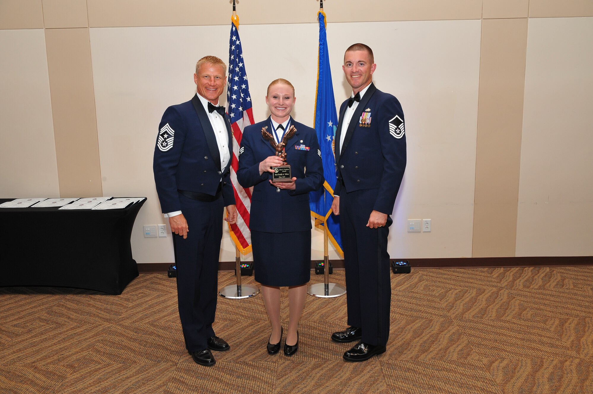 Senior Airman Matthew Kendall, 460th Operation Group mission crew chief, center, receives the Leadership Award during the Airman Leadership School graduation for class 14-E June 25, 2014, at the Leadership Development Center on Buckley Air Force Base, Colo. This award is presented to the graduate who displays the best overall characteristics of an effective leader. (U.S. Air Force photo by Senior Airman Phillip Houk/Released)