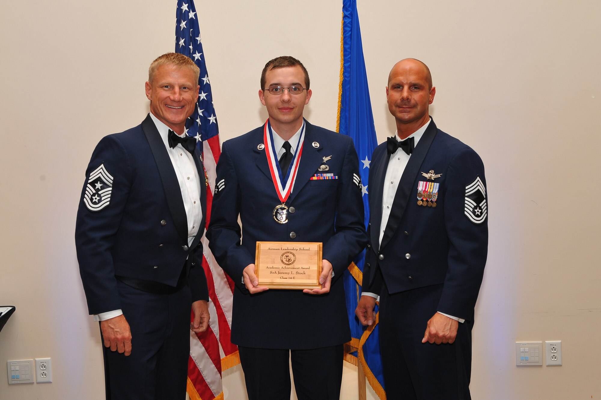 Chief Master Sgt. Craig S. Hall, 460th Space Wing command chief, left, and Chief Master Sgt. Kristopher Coats, 460th Comptroller Squadron financial flight chief, right, present the John L. Levitow Award to Senior Airman Emily A. Valois, 460th Medical Support Squadron medical records technician, during the Airman Leadership School graduation for class 14-E June 25, 2014, at the Leadership Development Center on Buckley Air Force Base, Colo. The Levitow award is presented to the graduate with the overall best leadership and academic achievement. (U.S. Air Force photo by Senior Airman Phillip Houk/Released)