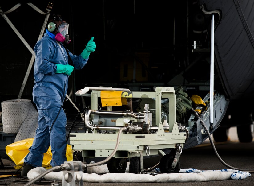 An Airman from the 910th Airlift Wing, Youngstown Air Reserve Station, Ohio, gives a “thumbs up” to an Airman to begin transferring insecticide to a C-130 Hercules June 25, 2014, at Joint Base Charleston, S.C. The spray crew was in Charleston to spray for mosquitos on JB Charleston and is the only unit of its kind in the Air Force.  (U.S. Air Force photo/Senior Airman Dennis Sloan)