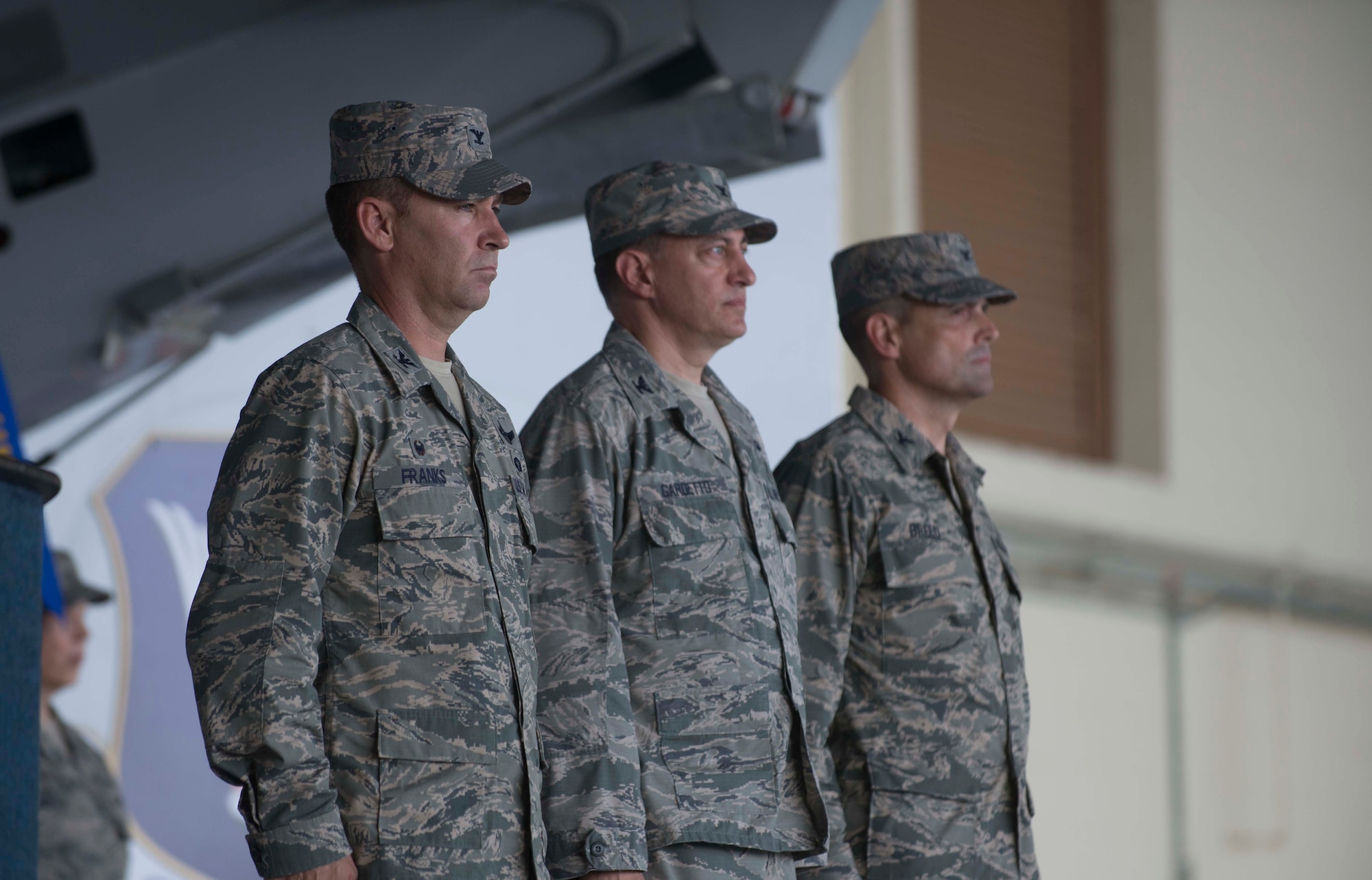 U.S. Air Force Col. Chad Franks, left, 23d Wing commander, Col. Paul Gardetto, center, and Col. Peter Breed stand for the posting of the colors during the 23d Medical Group change of command ceremony June 30, 2014, at Moody Air Force Base, Ga. Posting the colors is a military tradition in which all members honor the flag during the playing of the national anthem. (U.S. Air Force photo by Airman Dillian Bamman/Released)