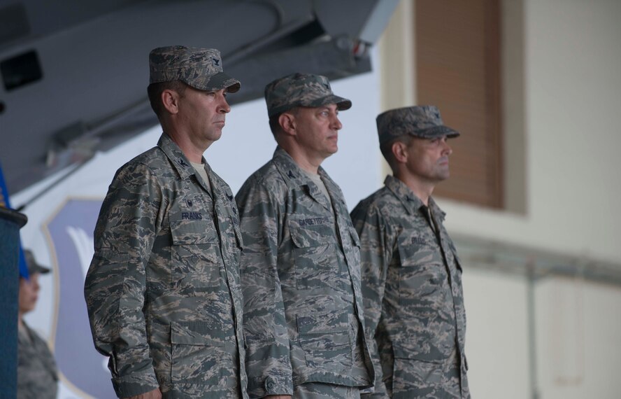 U.S. Air Force Col. Chad Franks, left, 23d Wing commander, Col. Paul Gardetto, center, and Col. Peter Breed stand for the posting of the colors during the 23d Medical Group change of command ceremony June 30, 2014, at Moody Air Force Base, Ga. Posting the colors is a military tradition in which all members honor the flag during the playing of the national anthem. (U.S. Air Force photo by Airman Dillian Bamman/Released)