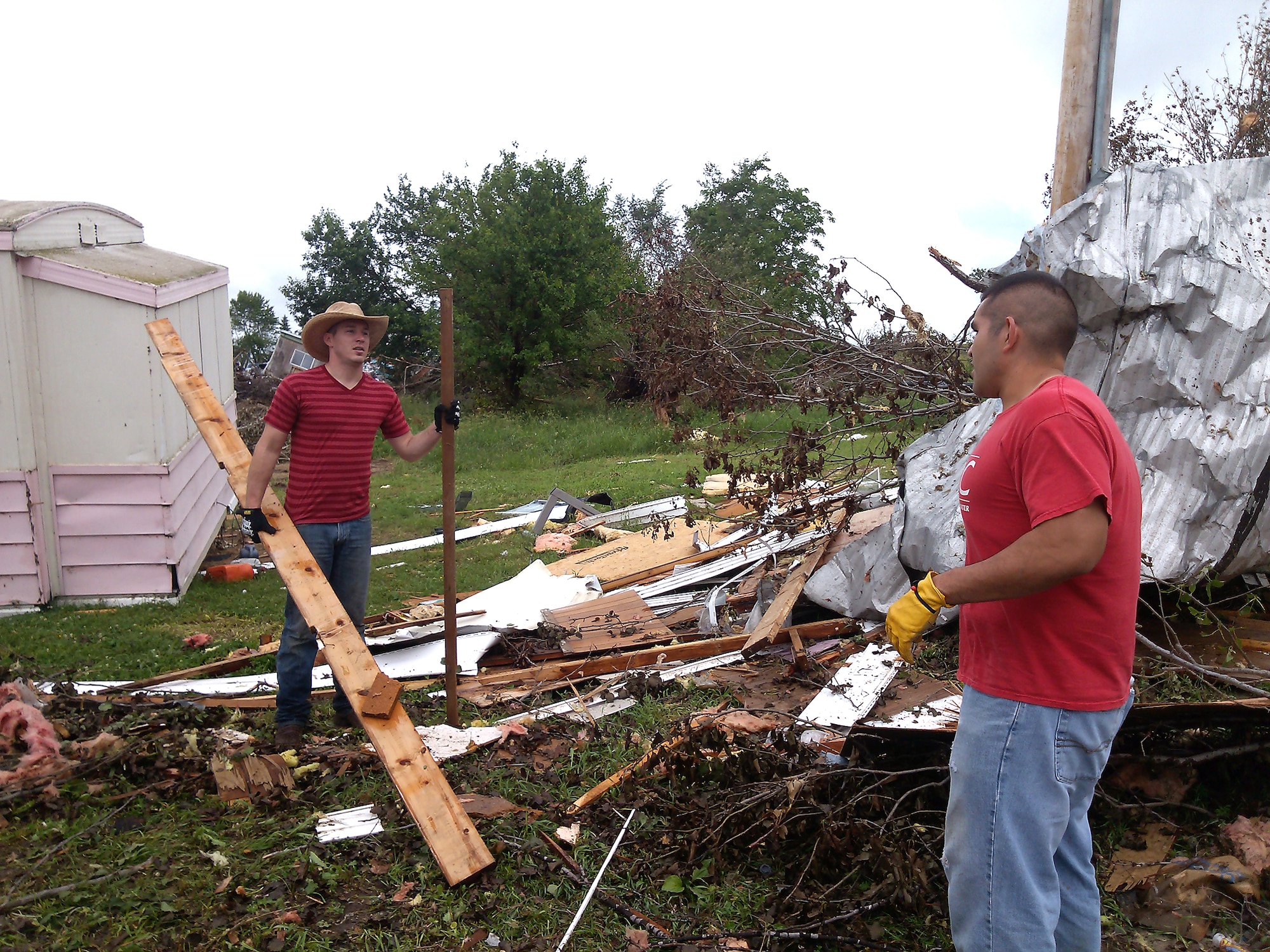 (Left to Right) Senior Airman Charles Little and Airman 1st Class Stephen Robles, contracting specialists from the 55th Contracting Squadron at Offutt Air Force Base, Nebraska, help remove debris June 22 in Wakefield, Nebraska. They volunteered to help with the cleanup of Wakefield following a tornado that struck the town June 16. (Courtesy photo)