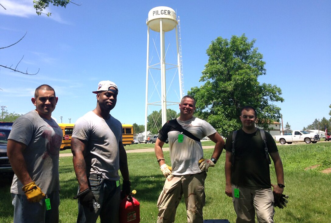 (Left to Right) Airman 1st Class Stephen Robles, U.S. Air Force Staff Sgt. Justin Lewis, U.S. Air Force Staff Sgt. Daniel Hinsley and Airman 1st Class Jeffrey Stuart, contracting specialists from the 55th Contracting Squadron at Offutt Air Force Base, Nebraska, pose for a photo June 21 in Pilger, Nebraska. They volunteered to help with the cleanup of Pilger following a tornado that struck the town June 16. Approximately 75 percent of the town was destroyed by the tornado. (Courtesy photo)