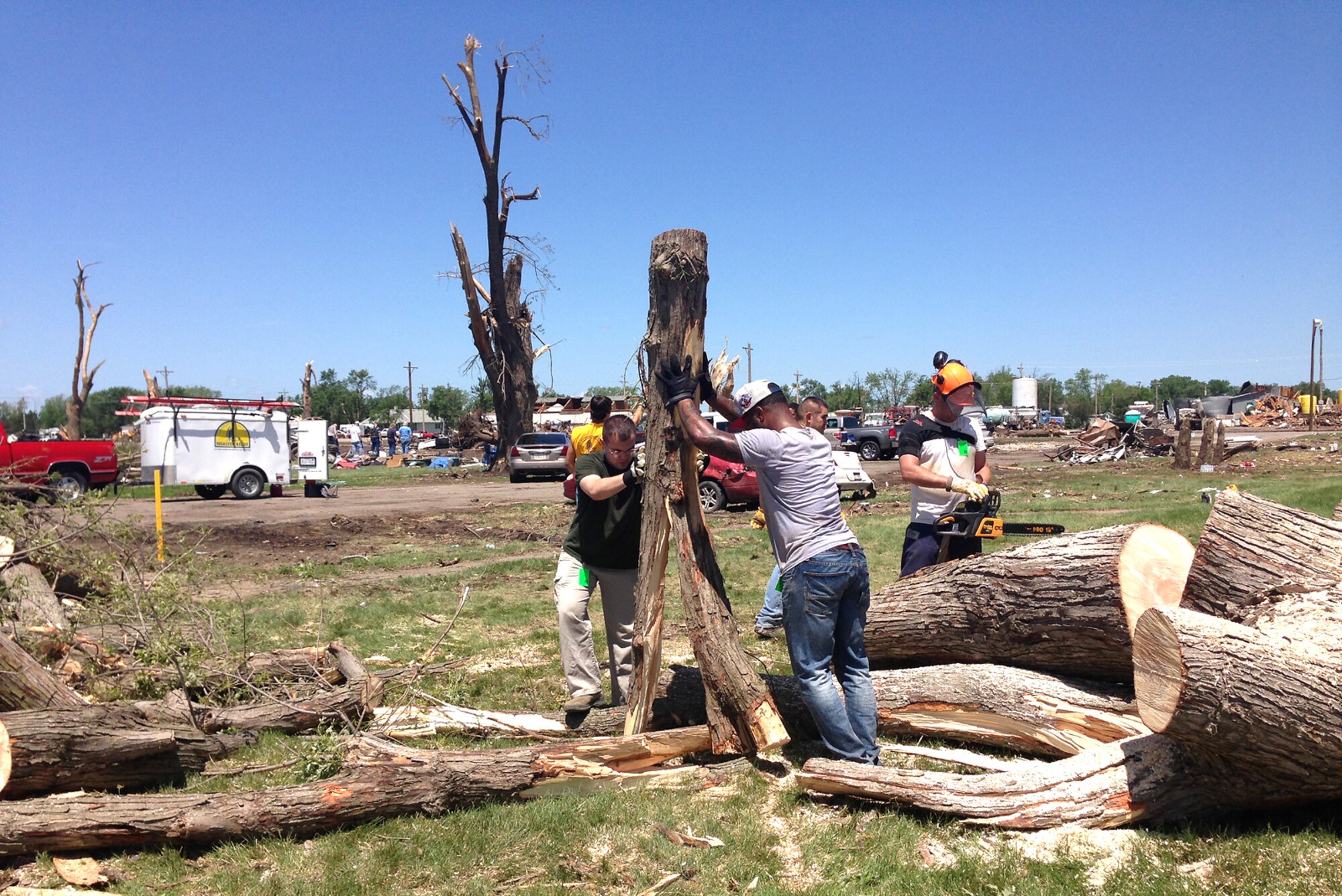 (Left to Right) Airman 1st Class Jeffrey Stuart, U.S. Air Force Staff Sgt. Justin Lewis, and U.S. Air Force Staff Sgt. Daniel Hinsley, contracting specialists from the 55th Contracting Squadron at Offutt Air Force Base, Nebraska, help remove debris June 21 in Pilger, Nebraska. They volunteered to help with the cleanup of Pilger following a tornado that struck the town June 16. Approximately 75 percent of the town was destroyed by the tornado. (Courtesy photo)