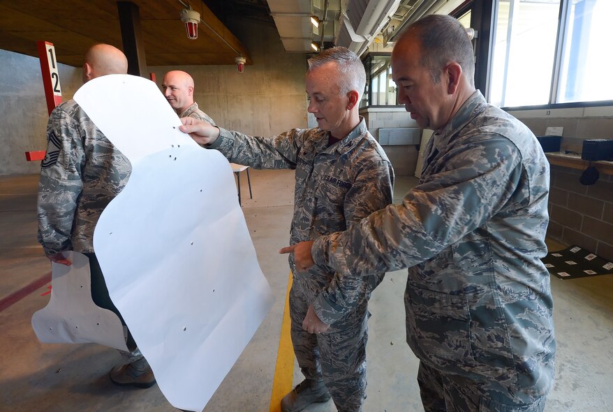 Col. Kevin Murphy, 436th Medical Group commander, holds up a paper target silhouette for inspection while Col. Thomas Reppart, 436th Mission Support Group commander, points out holes toward the bottom of the target June 20, 2014, at Dover Air Force Base, Del. The two participated in a shooting competition between senior leadership of the 436th Airlift Wing at the Combat Arms Training and Maintenance range operated by the 436th Security Forces Squadron. (U.S. Air Force photo/Greg L. Davis) 