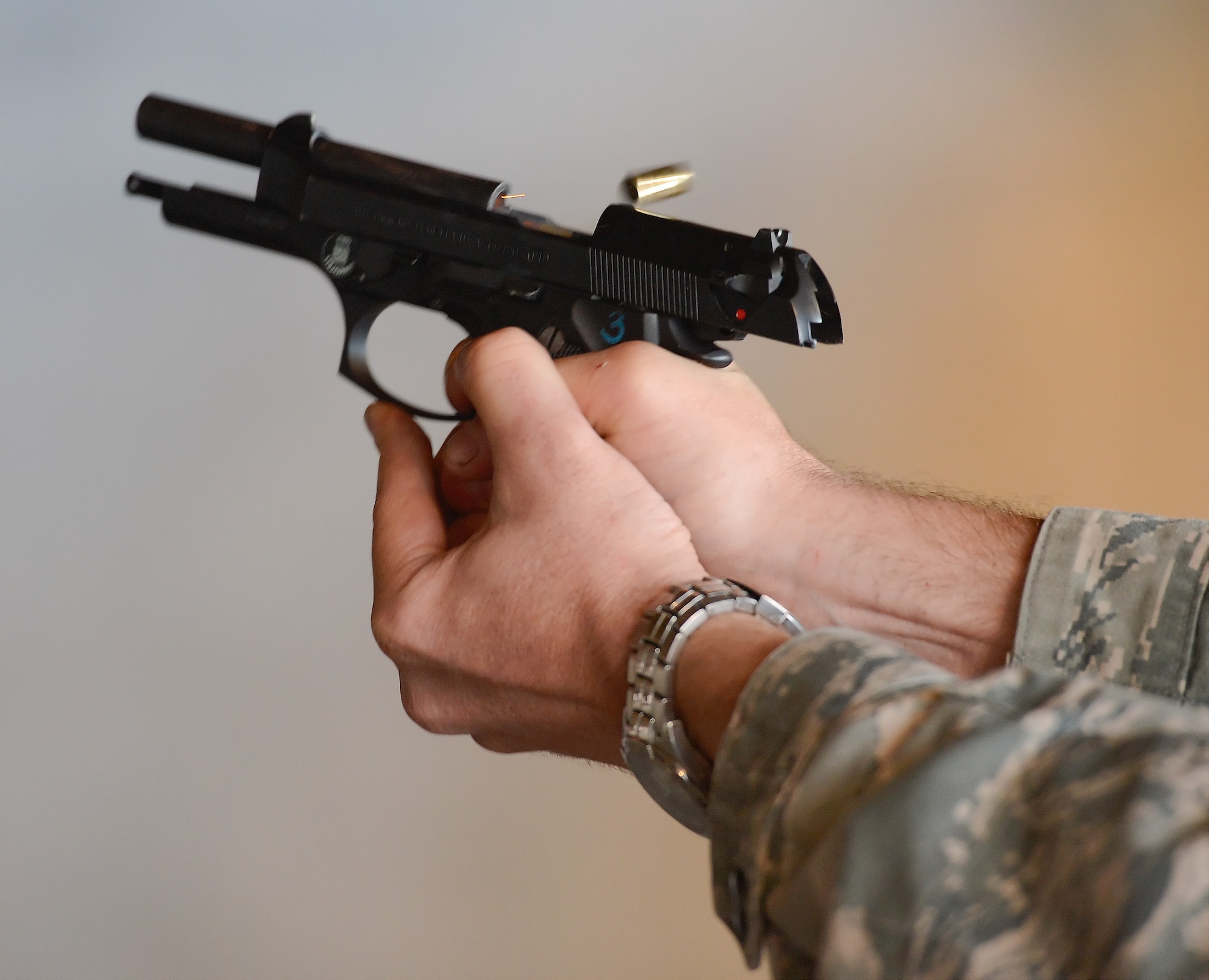 A brass shell is ejected from a 9 mm Beretta pistol after being fired at the Combat Arms Training and Maintenance range June 20, 2014, at Dover Air Force Base, Del. The 9 mm Beretta is the Air Force's standard side-arm and is being used here during a marksmanship refresher. (U.S. Air Force photo/Greg L. Davis)