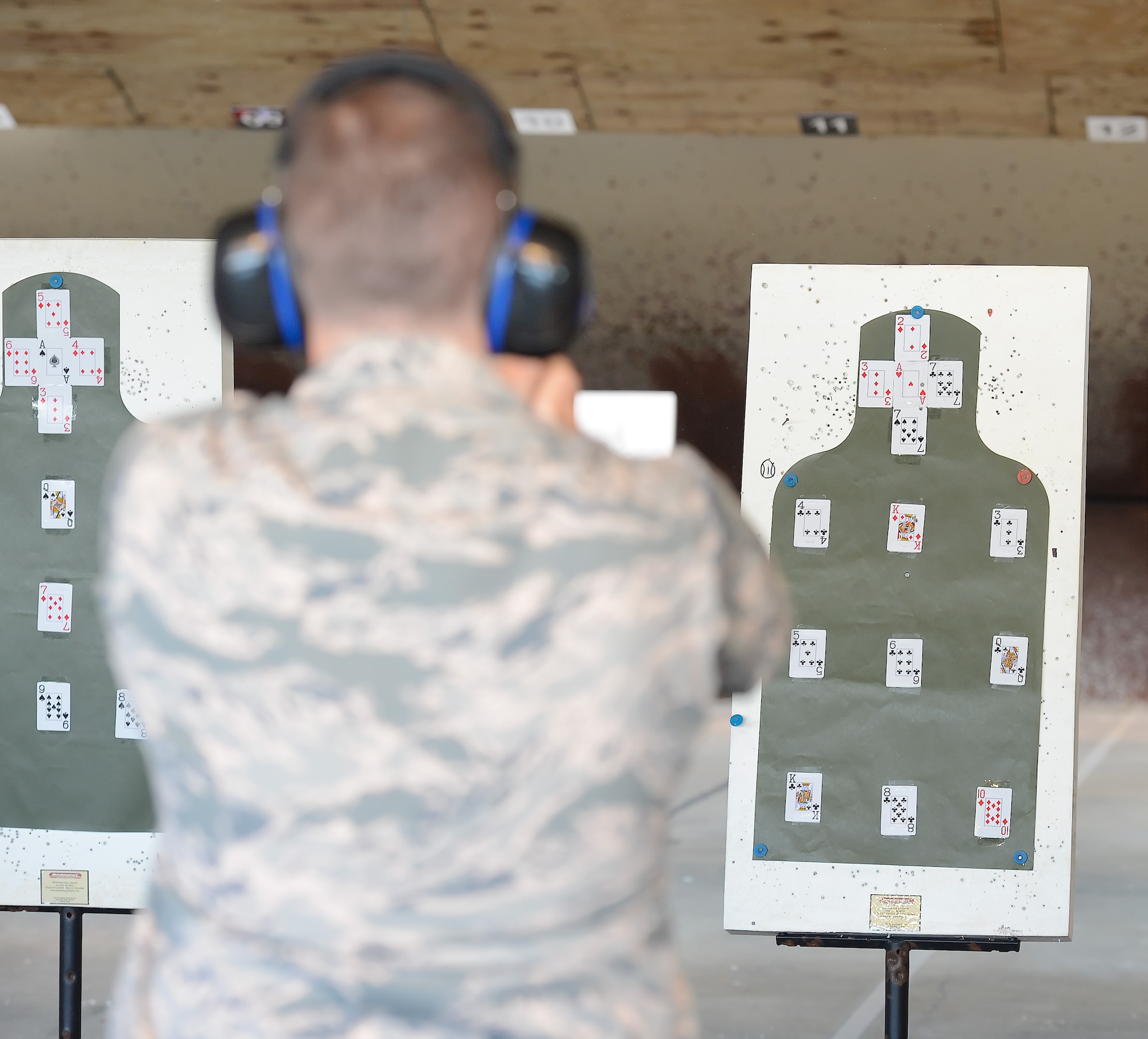 A shooter takes aim at a set of cards placed on a target during a senior leaders shooting competition on June 20, 2014, at Dover Air Force Base, Del. The friendly competition allowed leadership to refresh their marksmanship skills and took place at the Dover AFB Combat Arms and Maintenance Training range. (U.S. Air Force photo/Greg L. Davis) 