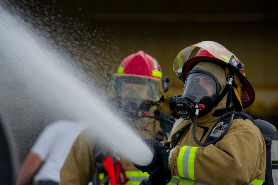 Members of the Burlington Fire Department put out a fire during training in Burlington, N.D., June 23, 2014. Burlington Fire Department is based solely on volunteerism, and they respond to 50-70 calls per year ranging, from wild land to structure fires.  (U.S. Air Force photo/Senior Airman Brittany Y. Bateman)