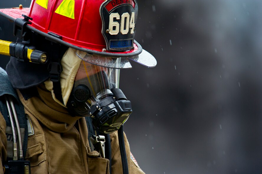 A firefighter watches as the helicopter trainer burns during a live fire training exercise in Burlington, N.D., June 23, 2014. Members of the Minot Air Force Base fire department trained Burlington volunteer firemen. (U.S. Air Force photo/Senior Airman Brittany Y. Bateman)