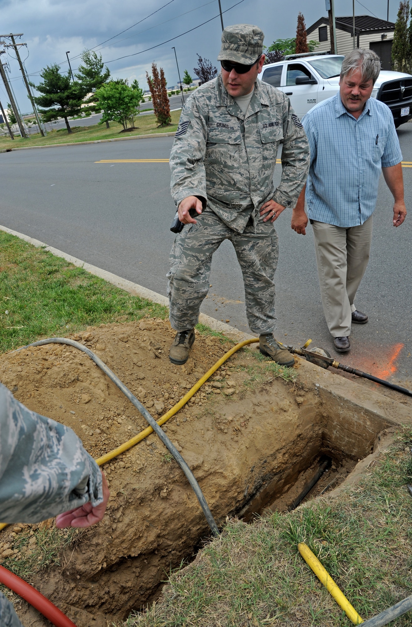 Tech. Sgt. Robert Grimes, 87th Civil Engineer Squadron, discusses a plan of action after arriving at a scene of a broken gas line June 25, 2014, at Joint Base McGuire-Dix-Lakehurst, N.J. Firefighters, emergency management personnel and security forces teamed up after arriving the call and defused the situation by shutting the gas off, evacuating the nearest building and setting up an alternate traffic route. (U.S. Air Force photo by Airman 1st Class Sean M. Crowe/Released)