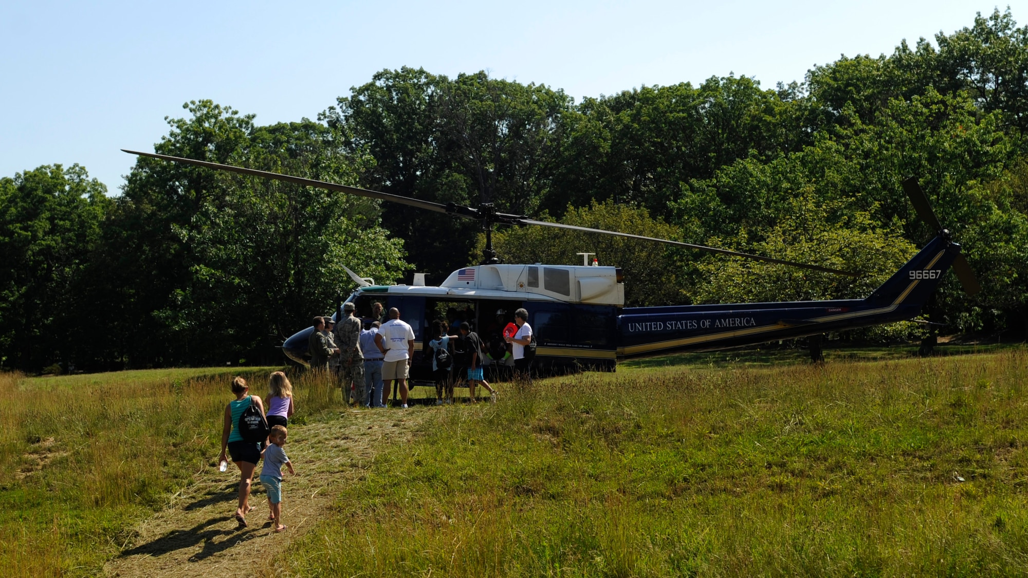 A UH-1N Iroquois from the 1st Helicopter Squadron sits on display for Operation KID Mode participants to view on Joint Base Andrews, Md., June 27, 2014. More than 70 military personnel volunteered for the third annual kid-friendly, mock deployment in-processing experience.  OKM featured a weapons demo, physical fitness, a bounce house, and an explosive ordnance disposal demo.  (U.S Air Force photo/Senior Airman Nesha Humes)