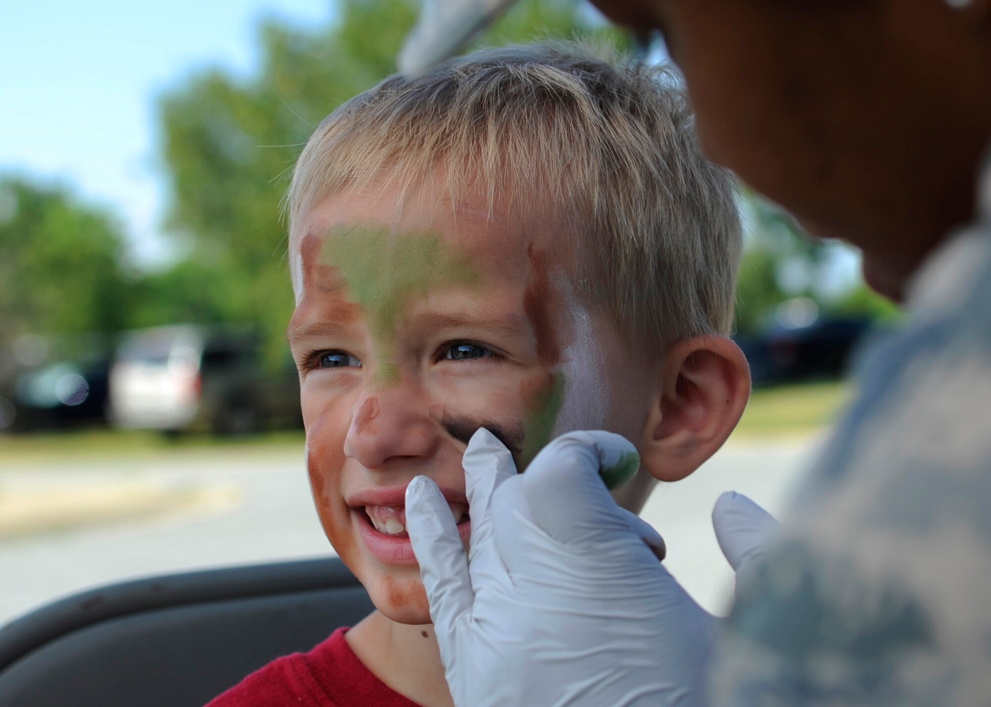James Szymanski, 3, has his face painted by Airman 1st Class Rosa Walters, 779th Medical Dental Operation Squadron mental health technician, for Operation KID Mode at Joint Base Andrews, Md., June 27, 2014. More than 240 JBA children registered for the Third Annual OKM. (U.S Air Force photo/Senior Airman Nesha Humes)