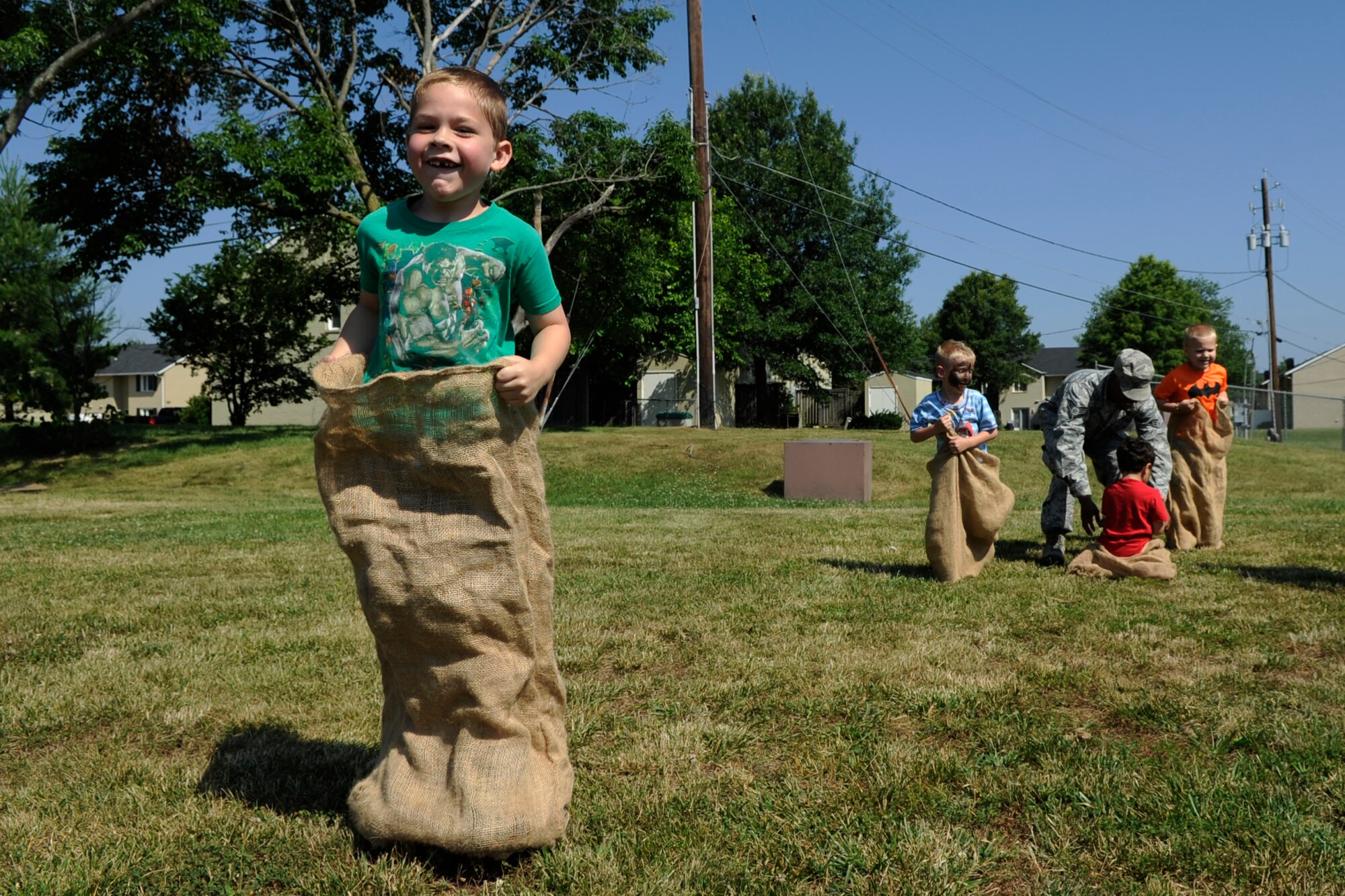 Justin Huddleston, 6, participates in a potato sack race during Operation KID Mode on Joint Base Andrews, Md., June 27, 2014. This is the third annual kid-friendly, pretend deployment in-processing event designed to familiarize children with their parents’ deployment experience. (U.S Air Force photo/Senior Airman Nesha Humes)