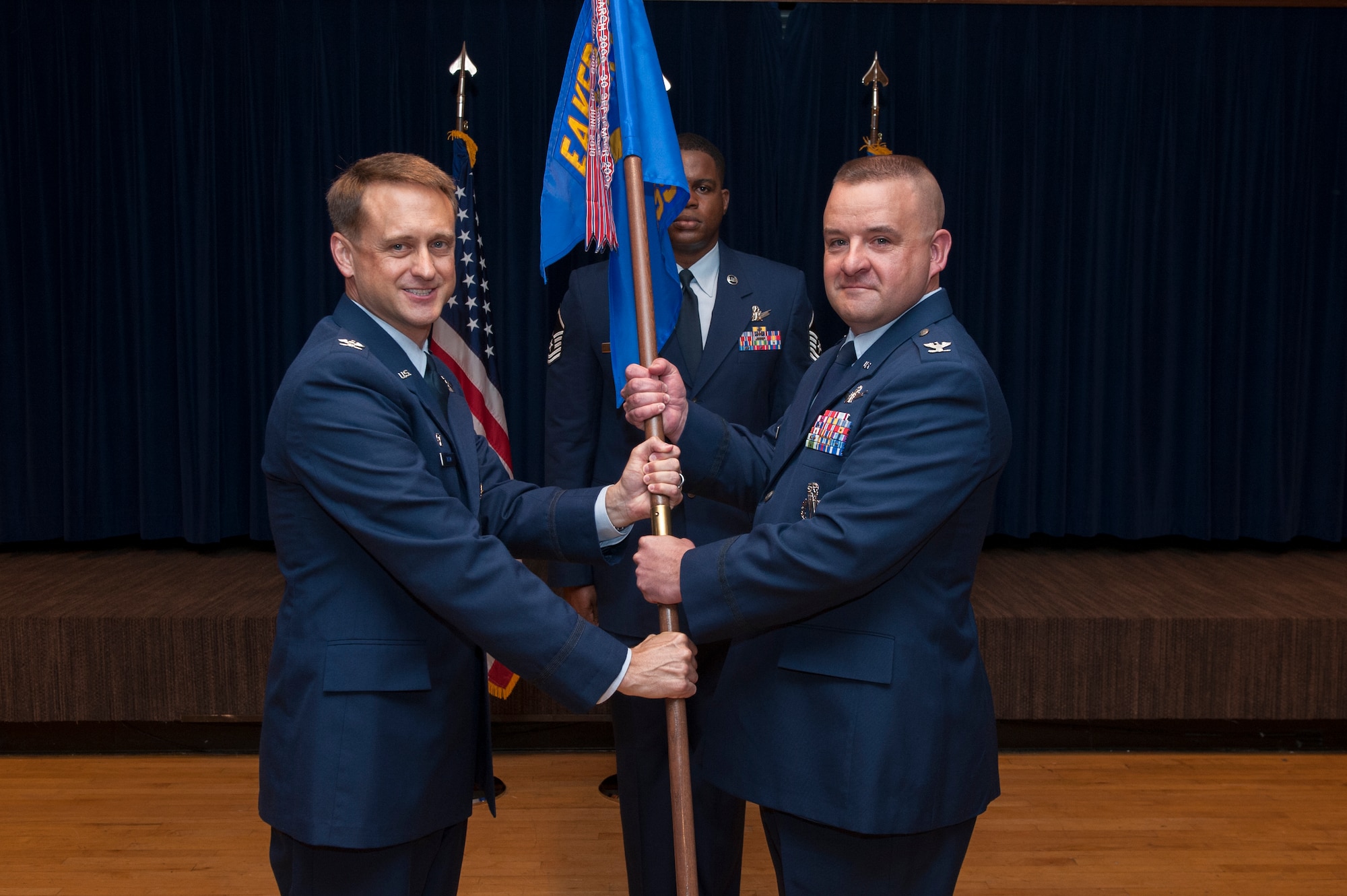PETERSON AIR FORCE BASE, Colo. - Col. Kenneth Tatum Jr. (left), commander of the Ira C. Eaker Center for Professional Development, Maxwell Air Force Base, Ala., passes the National Security Space Institute's flag to Col. James Forand during the NSSI change of command ceremony June 24 at The Club. Forand replaces outgoing commandant Col. Samuel Epperson Jr. NSSI provides space education and training to Air Force space professionals and the broader National Security Space community. (U.S. Air Force photo/Philip Carter)