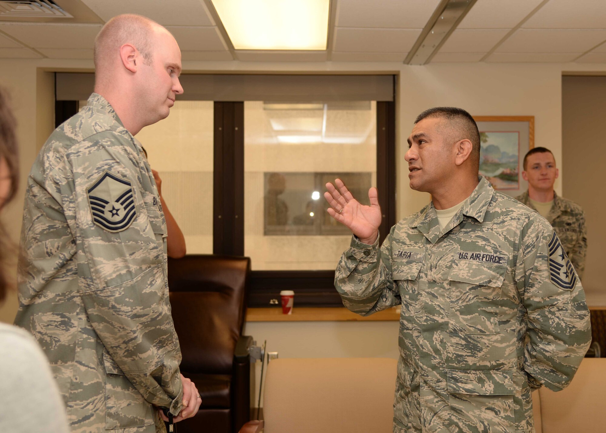 Chief Master Sgt. Gerardo Tapia, command chief, Air Education and Training Command, speaks to Master Sgt. Christopher Barker, a patient assigned to the 59th Medical Wing Patient Squadron, during a tour, June 27, 2014, at the Wilford Hall Ambulatory Surgical Center, Joint Base San Antonio-Lackland, Texas. Tapia visited the facility to meet with staff and patients. (U.S. Air Force photo/Staff Sgt. Jerilyn Quintanilla)  