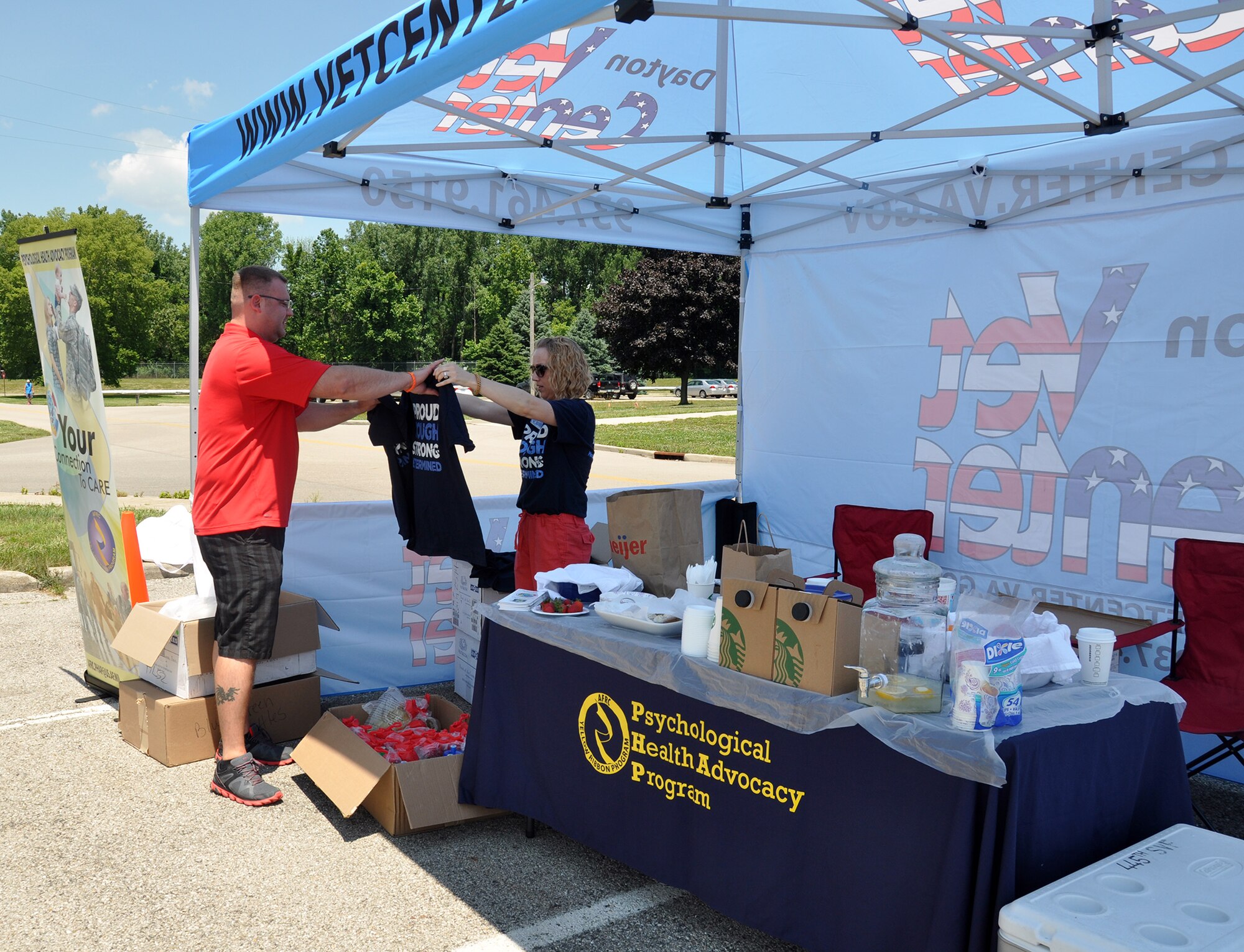WRIGHT-PATTERSON AIR FORCE BASE, Ohio – Pamela Boyd, North Region Psychological Health Advocacy Program outreach specialist, hands out t-shirts to attendees of the PHAP Post Traumatic Stress Disorder (PTSD) Awareness Day event June 27, 2014 at the 445th Airlift Wing. Approximately 85 people visited the PHAP information booth and received information about the disorder and the help that is available. A Department of Veterans Affairs Mobile Vet Center was also on site with staff members available to provide one-on-one counseling. Vet Centers across the country provide a broad range of counseling, outreach, and referral services to combat Veterans and their families. They guide veterans and their families through many of the major adjustments in lifestyle that often occur after a veteran returns from combat. Services may include individual and group counseling in areas such as PTSD, alcohol and drug assessment, and suicide prevention referrals. (U.S. Air Force photo/Stacy Vaughn)