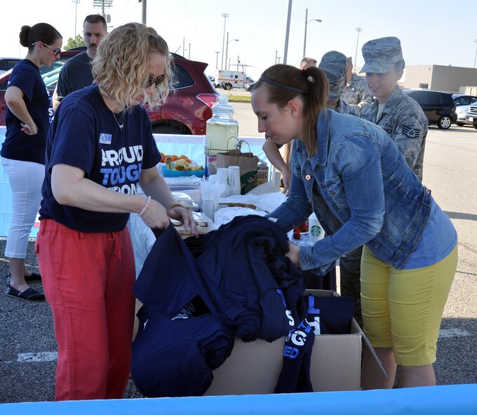 WRIGHT-PATTERSON AIR FORCE BASE, Ohio – Pamela Boyd, North Region Psychological Health Advocacy Program outreach specialist, hands out t-shirts to attendees of the PHAP Post Traumatic Stress Disorder (PTSD) Awareness Day event June 27, 2014 at the 445th Airlift Wing. Approximately 85 people visited the PHAP information booth and received information about the disorder and the help that is available. A Department of Veterans Affairs Mobile Vet Center was also on site with staff members available to provide one-on-one counseling. Vet Centers across the country provide a broad range of counseling, outreach, and referral services to combat Veterans and their families. They guide veterans and their families through many of the major adjustments in lifestyle that often occur after a veteran returns from combat. Services may include individual and group counseling in areas such as PTSD, alcohol and drug assessment, and suicide prevention referrals. (U.S. Air Force photo/Stacy Vaughn)