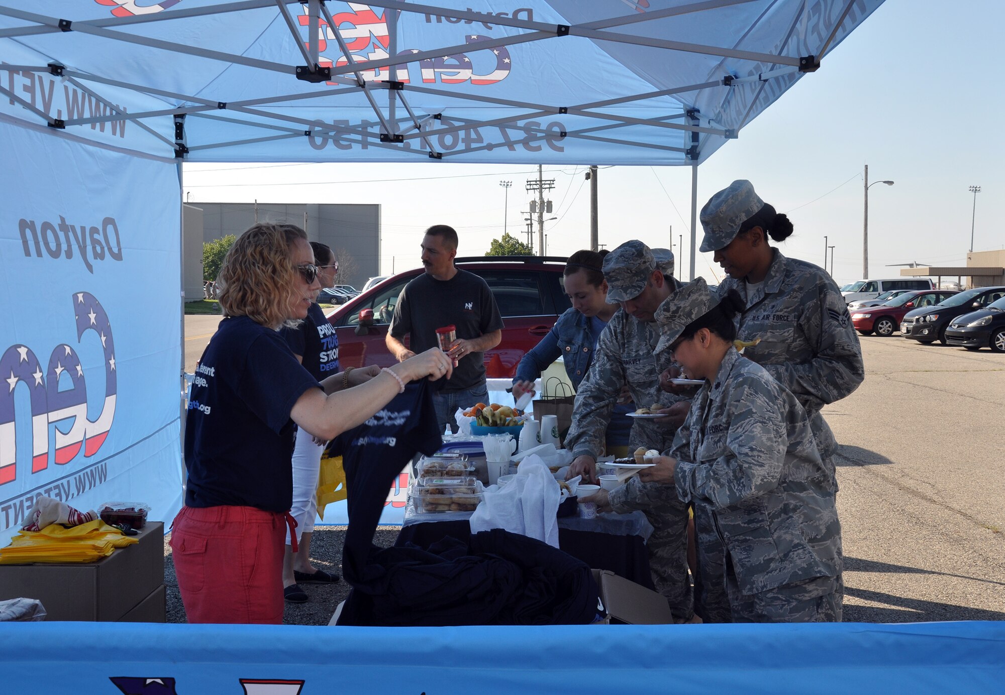 WRIGHT-PATTERSON AIR FORCE BASE, Ohio – Pamela Boyd, North Region Psychological Health Advocacy Program outreach specialist, hands out t-shirts to attendees of the PHAP Post Traumatic Stress Disorder (PTSD) Awareness Day event June 27, 2014 at the 445th Airlift Wing. Approximately 85 people visited the PHAP information booth and received information about the disorder and the help that is available. A Department of Veterans Affairs Mobile Vet Center was also on site with staff members available to provide one-on-one counseling. Vet Centers across the country provide a broad range of counseling, outreach, and referral services to combat Veterans and their families. They guide veterans and their families through many of the major adjustments in lifestyle that often occur after a veteran returns from combat. Services may include individual and group counseling in areas such as PTSD, alcohol and drug assessment, and suicide prevention referrals. (U.S. Air Force photo/Stacy Vaughn)