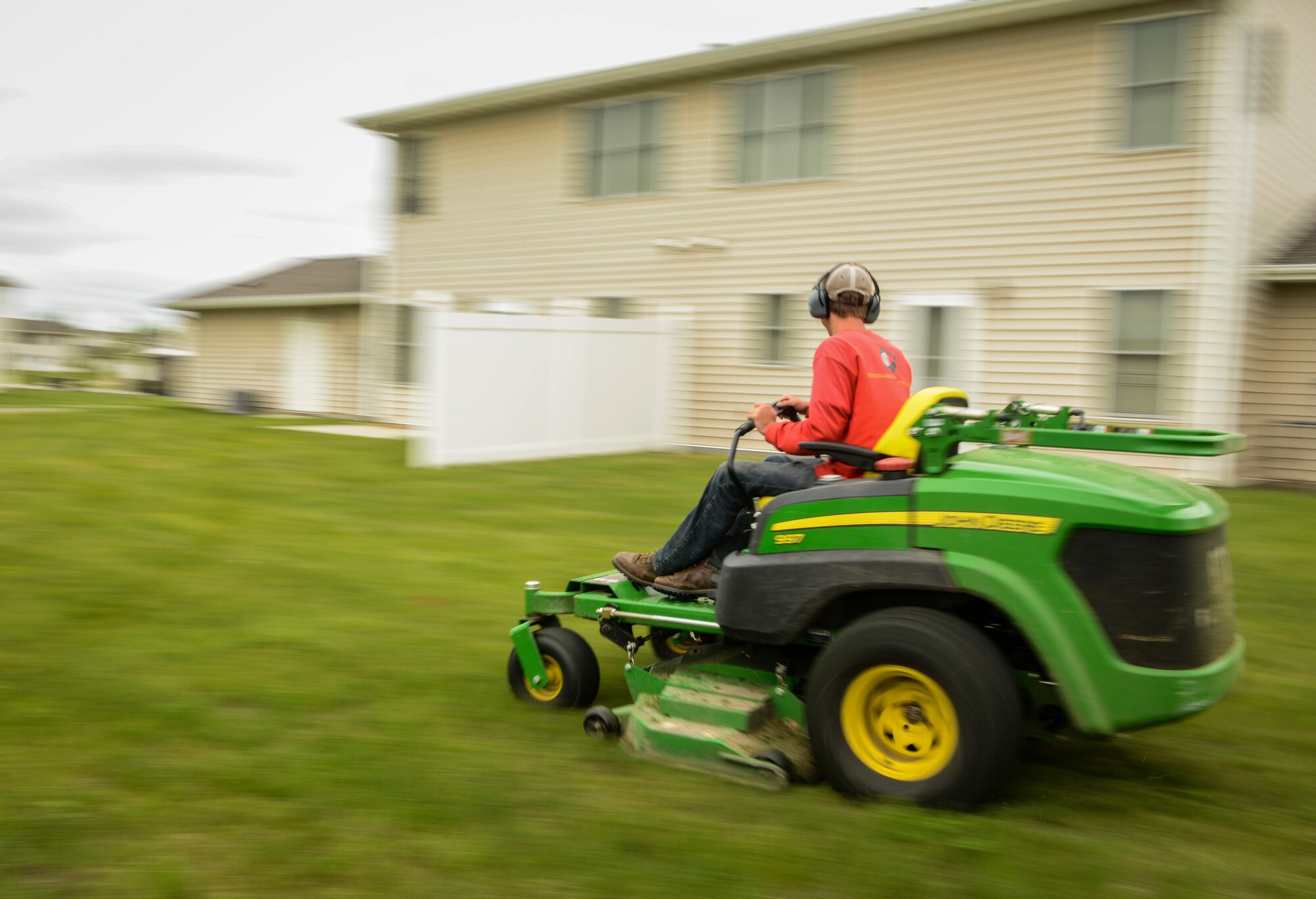 Douglas Dicken, a contractor working for Balfour Beatty Communities, mows the lawn near a residence in housing on Minot Air Force Base, N.D., June 13, 2014. According to the BBC residents guide, residents in housing are responsible for watering the lawn trees and shrubs that surround their home as well as mowing their back yard, if they have a fence, and trimming their fence lines. (U.S. Air force photo/Senior Airman Stephanie Morris)
