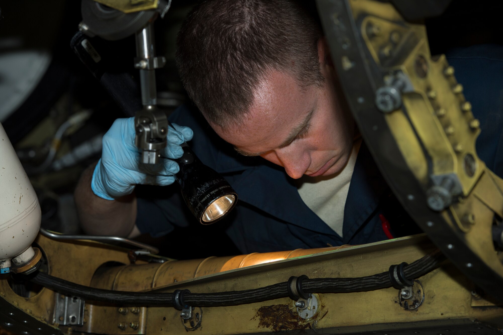 U.S. Air Force Staff Sgt. Todd Hughes, 52nd Equipment Maintenance Squadron phase floor chief from Williamsport, Pa., performs an engine bay inspection on an F-16 Fighting Falcon fighter aircraft at Spangdahlem Air Base, Germany, June 27, 2014. The 52nd EMS executes inspections of the aircraft on an hourly basis, tearing down the aircraft before building it back up. (U.S. Air Force photo by Staff Sgt. Christopher Ruano/Released)