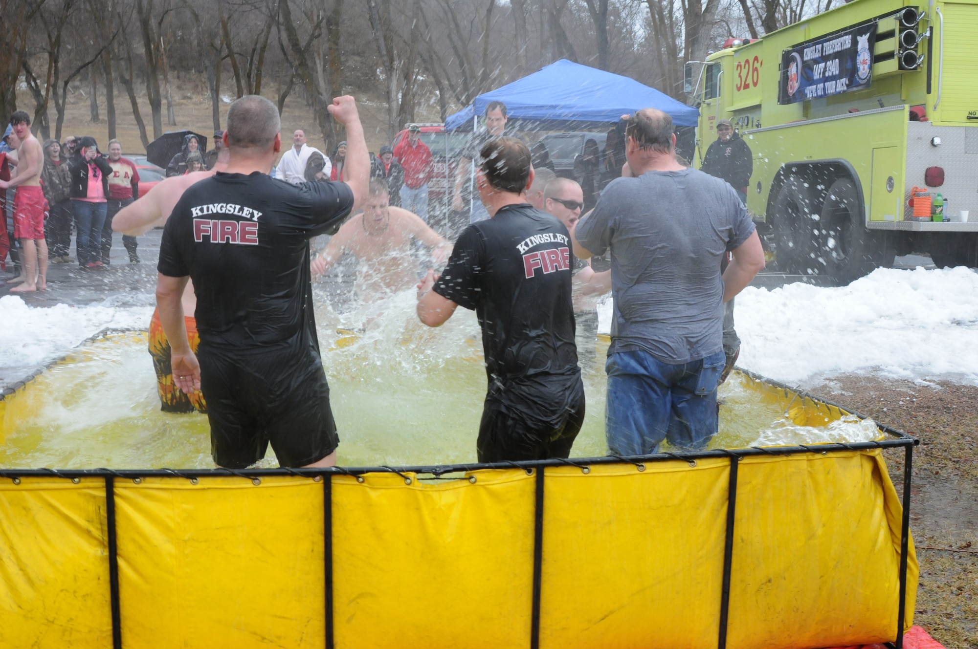 173rd Fighter Wing Firefighter Kyle Tecmire, center, lands in icy water during the Polar Plunge held on a rainy Saturday, Feb. 8, 2014 at Moore Park, Klamath Falls, Ore. The 173rd Fire Department raised nearly $600 for the event and they say they are excited to see what they can do next year. (U.S. Air National Guard photo by Tech. Sgt. Jefferson Thompson/Released)