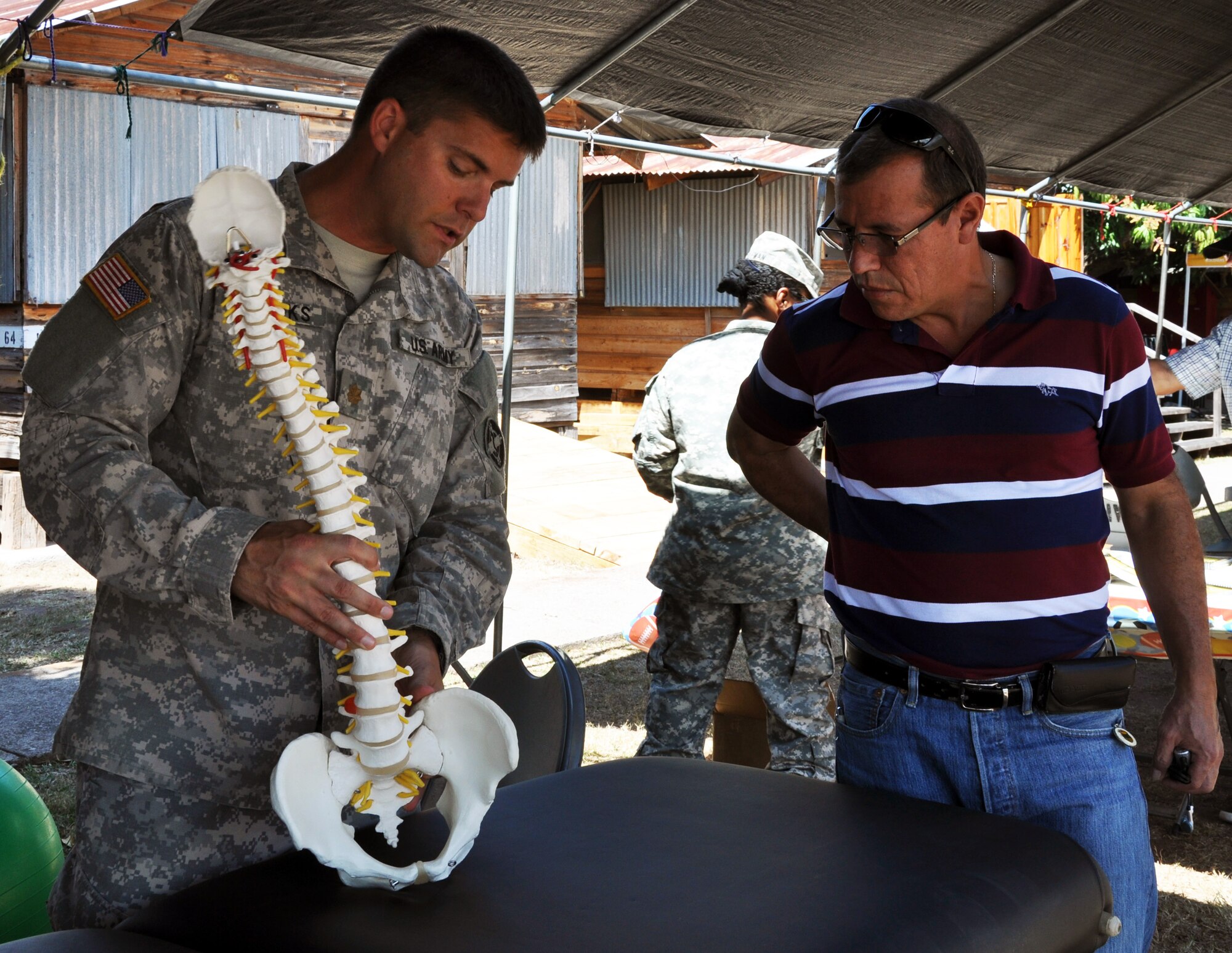 U.S. Army Maj. Joshua Brooks, the physical therapy officer in charge for Joint Task Force Bravo's Medical Element (MEDEL), visits with Martin Chahin, a Foreign Service National employee, during a Health Fair at Soto Cano Air Base, Honduras, Feb. 27, 2014. During the fair, service members as well as civilian employees on base were able to receive free health screenings and a variety of medical tests and services. (U.S. Air Force photo by Capt. Zach Anderson)