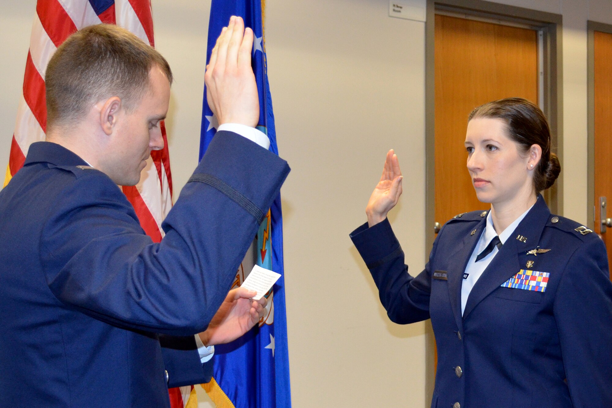U.S. Air Force Capt. Diana Wolczek-Evans, 307th Force Support Squadron executive officer, is sworn in by her husband, Capt. Chris Evans, as she recites the oath of office to reenter the regular Air Force, Feb. 28, 2014, Barksdale Air Force Base, La. Wolczek-Evans is a nurse and has been working the past two and a half years toward this career goal. (U.S. Air Force photo by Senior Master Sgt. Jessica Daurizio/Released)

