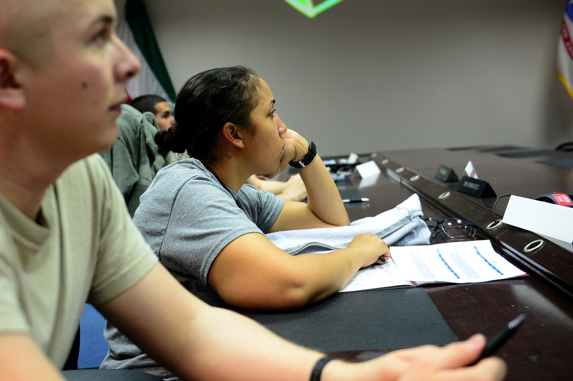 Senior Airman Chance Nelson (left), a medical technician with the 386th Expeditionary Medical Group, and Tech. Sgt. Sirrena Drummond, an analyst with 386th Expeditionary Logistics Readiness Squadron, listen to a lecture on exercise physiology by Maj. (Dr.) Sean Martin.  Nelson and Drummond are participants in the inaugural class of the Marauders Elite program.  The program was designed by Maj. Martin and a team of medical personnel to provide deployed Airmen with the medical science behind fitness.  (U.S. Air Force photo by Senior Master Sgt. Burke Baker)