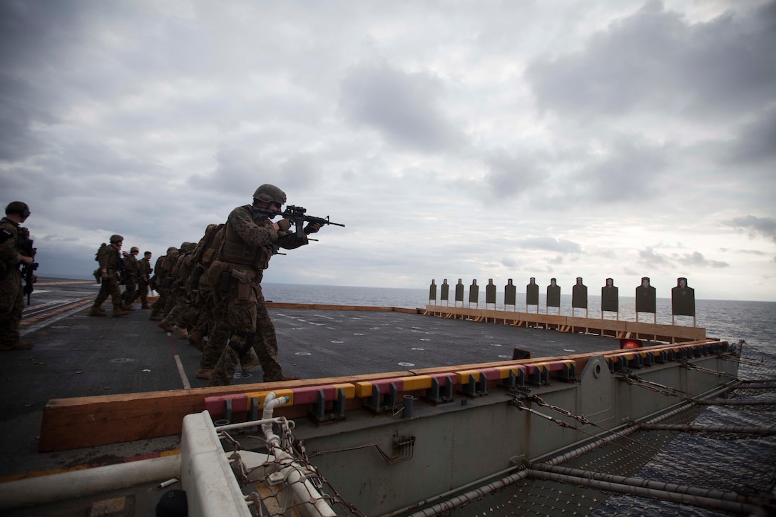 USS BONHOMME RICHARD, At Sea - Marines and sailors with the Maritime Raid Force, 31st Marine Expeditionary Unit, approach and engage paper targets during a live fire exercise on the flight deck of the USS Bonhomme Richard (LHD 6) here, March 2. The Marines shot the targets from multiple distances while maintaining awareness of their surroundings. The 31st MEU is currently conducting amphibious integration training alongside Amphibious Squadron 11 while deployed for its regularly scheduled Spring Patrol. (Official U.S. Marine Photo by Cpl. Henry Antenor)