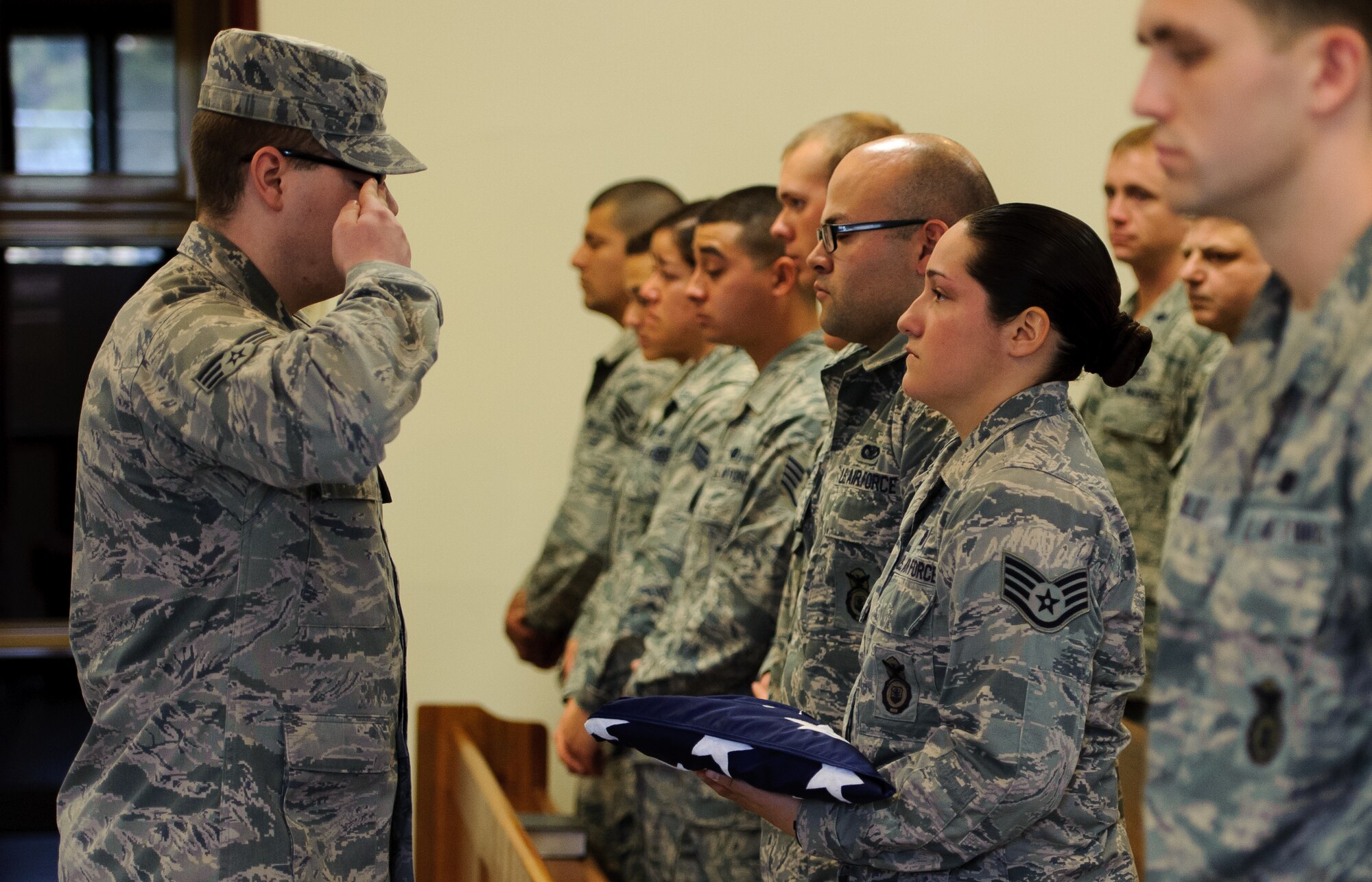 Staff Sgt. Tatiana Carbocci, 8th Security Forces Squadron military working dog handler, right, is presented a flag during a memorial ceremony for her military working dog Rico at Kunsan Air Base, Republic of Korea, Feb. 28, 2014. For more than nine years, Rico served the Wolf Pack as an explosive detection dog, ensuring the security of Kunsan. (U.S. Air Force photo by Senior Airman Armando A. Schwier-Morales/Released)