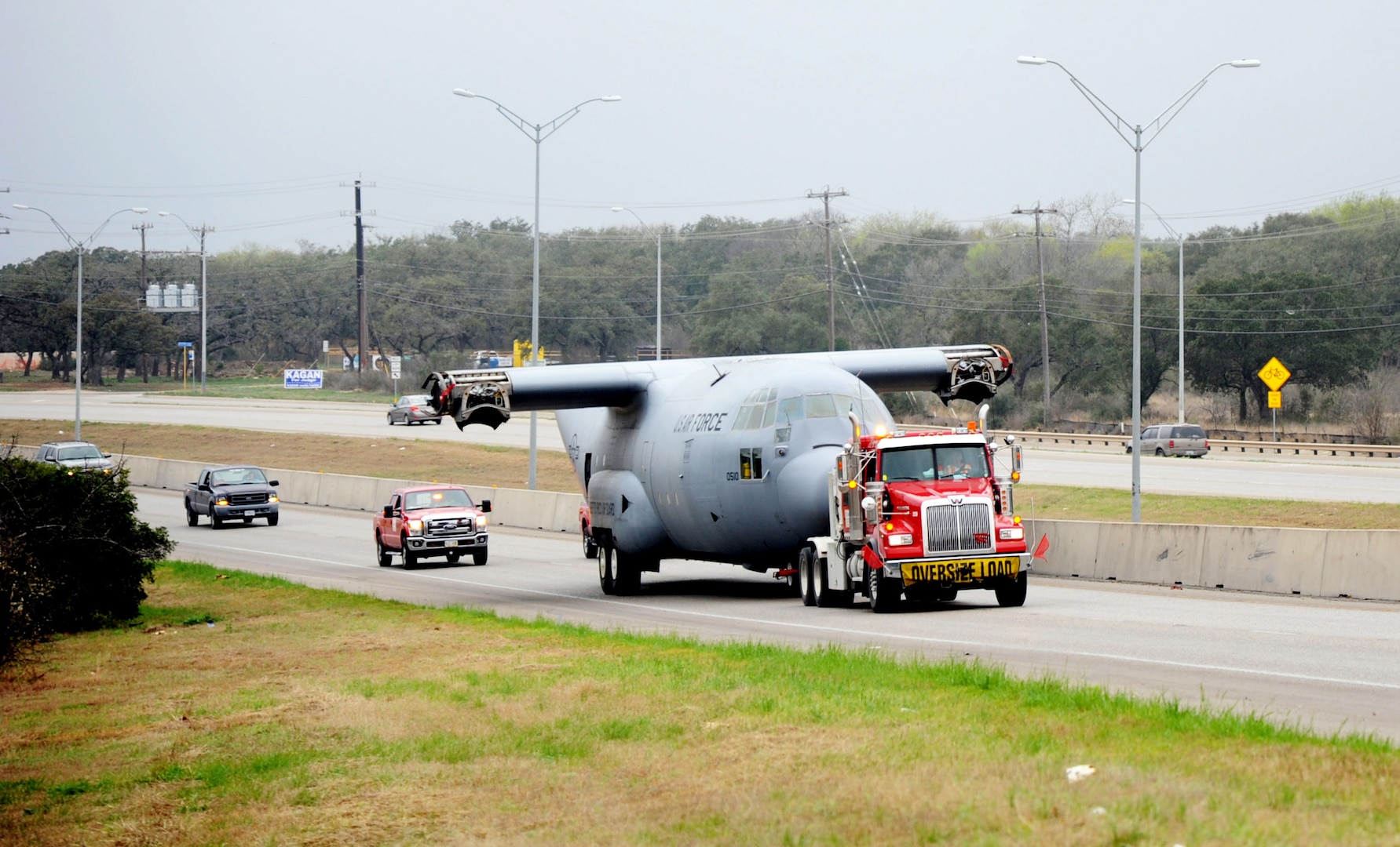 A retired and partially disassembled Air Force C-130 Hercules cargo aircraft is towed across major San Antonio highways March 2 enroute from Joint Base San Antonio-Lackland to the 937th Training Group Medical Readiness Training Center at JBSA-Camp Bullis. C-130s are capable of operating from rough, dirt strips and is the prime transport for airdropping troops and equipment into hostile areas. (U.S. Air Force photo by Airman 1st Class Kenna Jackson)