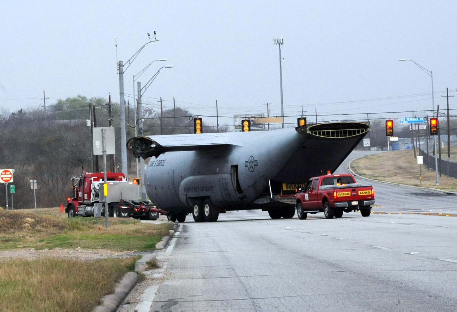 A retired and partially disassembled Air Force C-130 Hercules cargo aircraft is escorted by contractor World Wide Aircraft Recovery and local volunteers March 2 enroute to the Medical Readiness Training Center at Joint Base San Antonio-Camp Bullis. The 502nd Trainer Development Squadron members at JBSA-Randolph were responsible for the aircraft's four-hour move and will also accomplish the simulation project inside the aircraft that will simulate sights, sounds and smells of a medic's combat environment. (U.S. Air Force photo by Airman 1st Class Kenna Jackson)