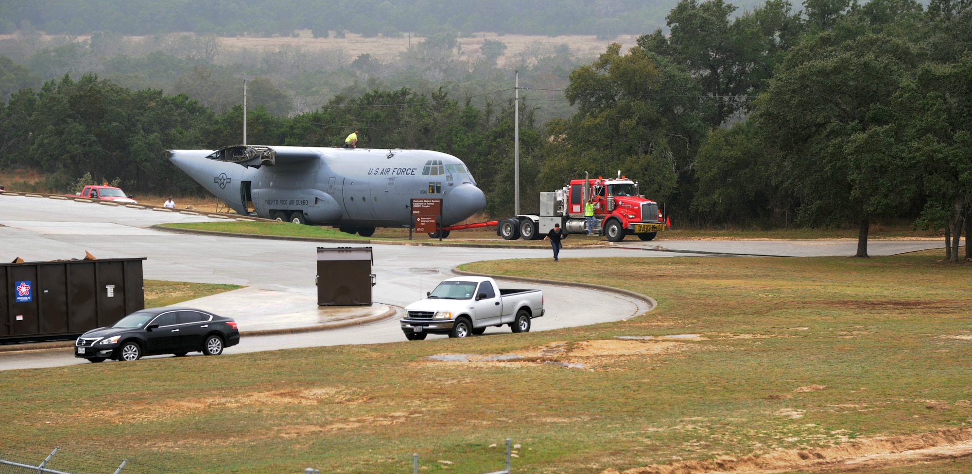 A retired and partially disassembled Air Force C-130 Hercules cargo aircraft arrives at Joint Base San Antonio-Camp Bullis March 2 after a 4-hour transport from JBSA-Lackland. The move took the C-130 across two major highways and was successfully accomplished through the combined efforts of 502nd Trainer Development Squadron members from JBSA-Randolph, 502nd Security Forces Squadron members at JBSA-Lackland, San Antonio Police and local volunteers, and contractor World Wide Aircraft Recovery. (U.S. Air Force photo by Airman 1st Class Alexandria Slade)