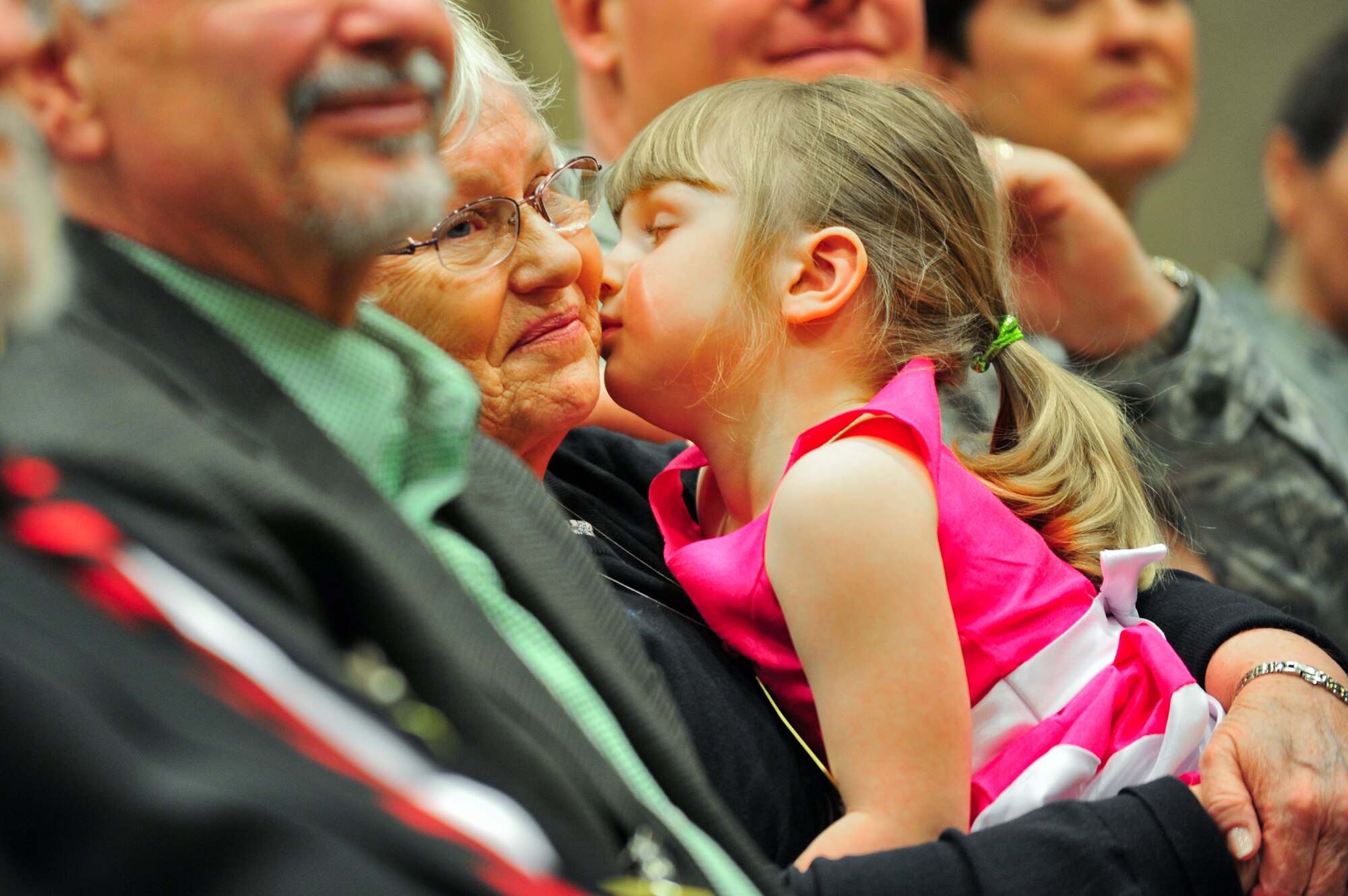 The daughter of Air Force Reserve Lt. Col. Leland K. Leonard kisses her grandmother March 1, 2014 on Schriever Air Force Base, Colo. Leonard’s family members attended the ceremony where he assumed command of the 7th Space Operations Squadron. (U.S. Air Force photo/Tech. Sgt. Nicholas B. Ontiveros)