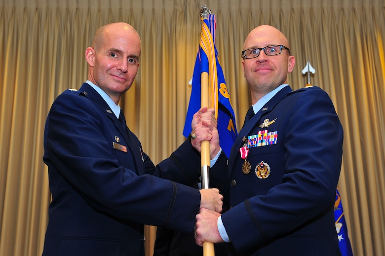 Air Force Reserve Lt. Col. Michael A. Assid, acting 310th Operations Group  commander (left), presents the 7th Space Operations Squadron guidon to AF Reserve Lt. Col. Leland K. Leonard March 1, 2014, on Schriever Air Force Base, Colo. Leonard assumed command of the squadron during the ceremony. (U.S. Air Force photo/Tech. Sgt. Nicholas B. Ontiveros)
