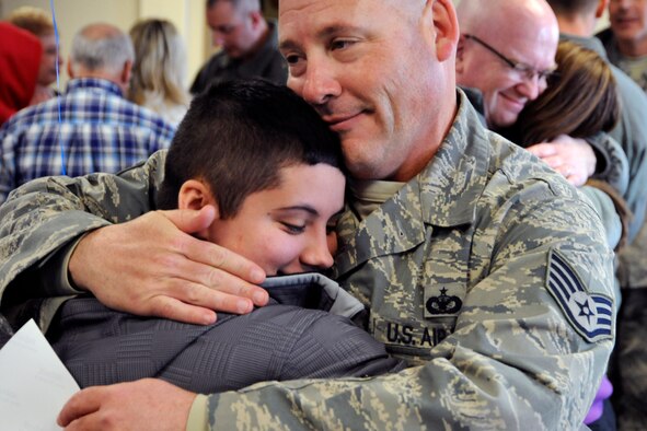 SSgt Andrew White, 127th Security Forces Squadron, receives hugs from his family on March 2, 2014, at Selfridge Air National Guard Base, Mich., after being deployed for 6 months to southwest Asia. (U.S. Air National Guard photo by John S. Swanson / Released)